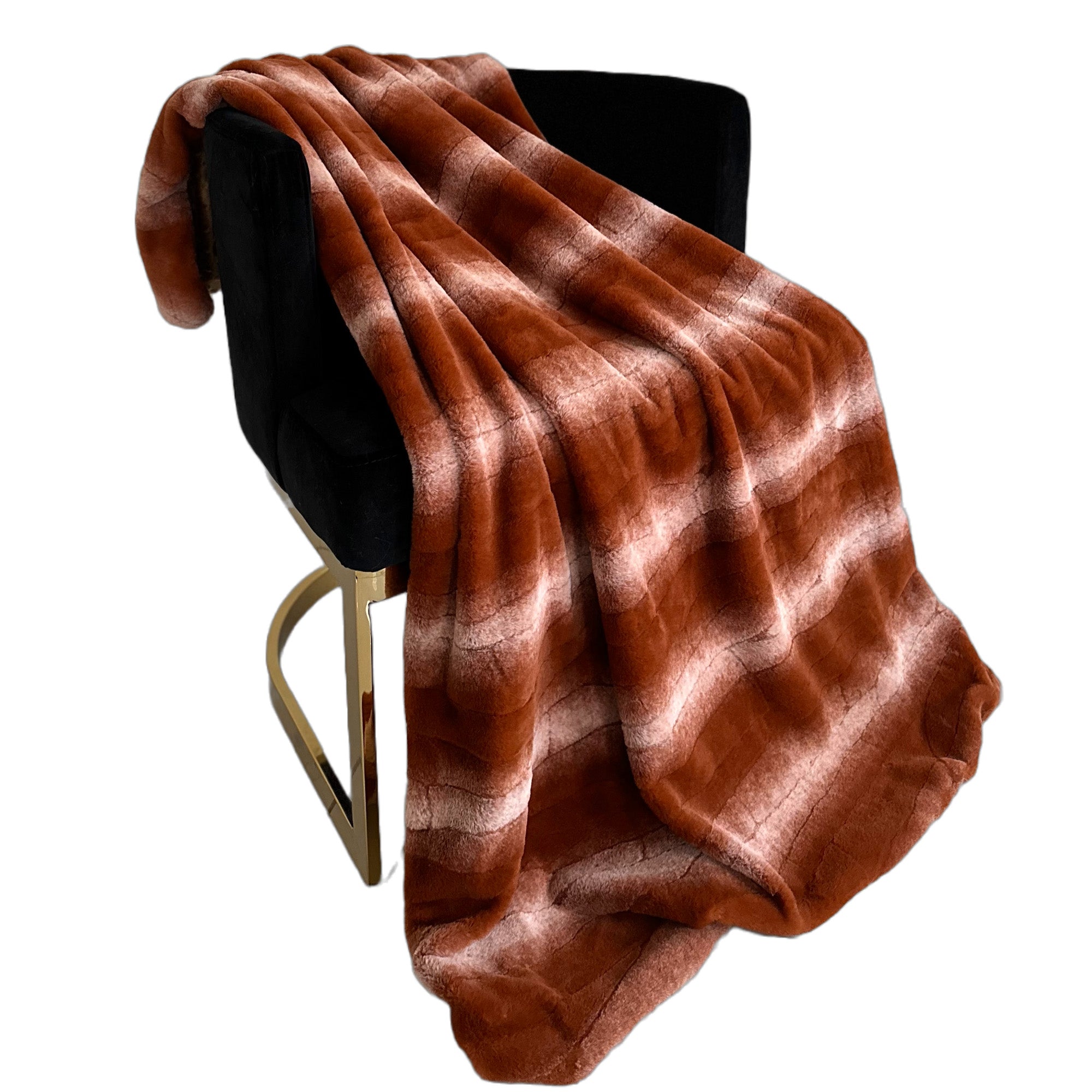 Plutus Orange Brown Faux Fur Luxury Throw Blanket draped elegantly over a couch, showcasing its rich color and soft texture.