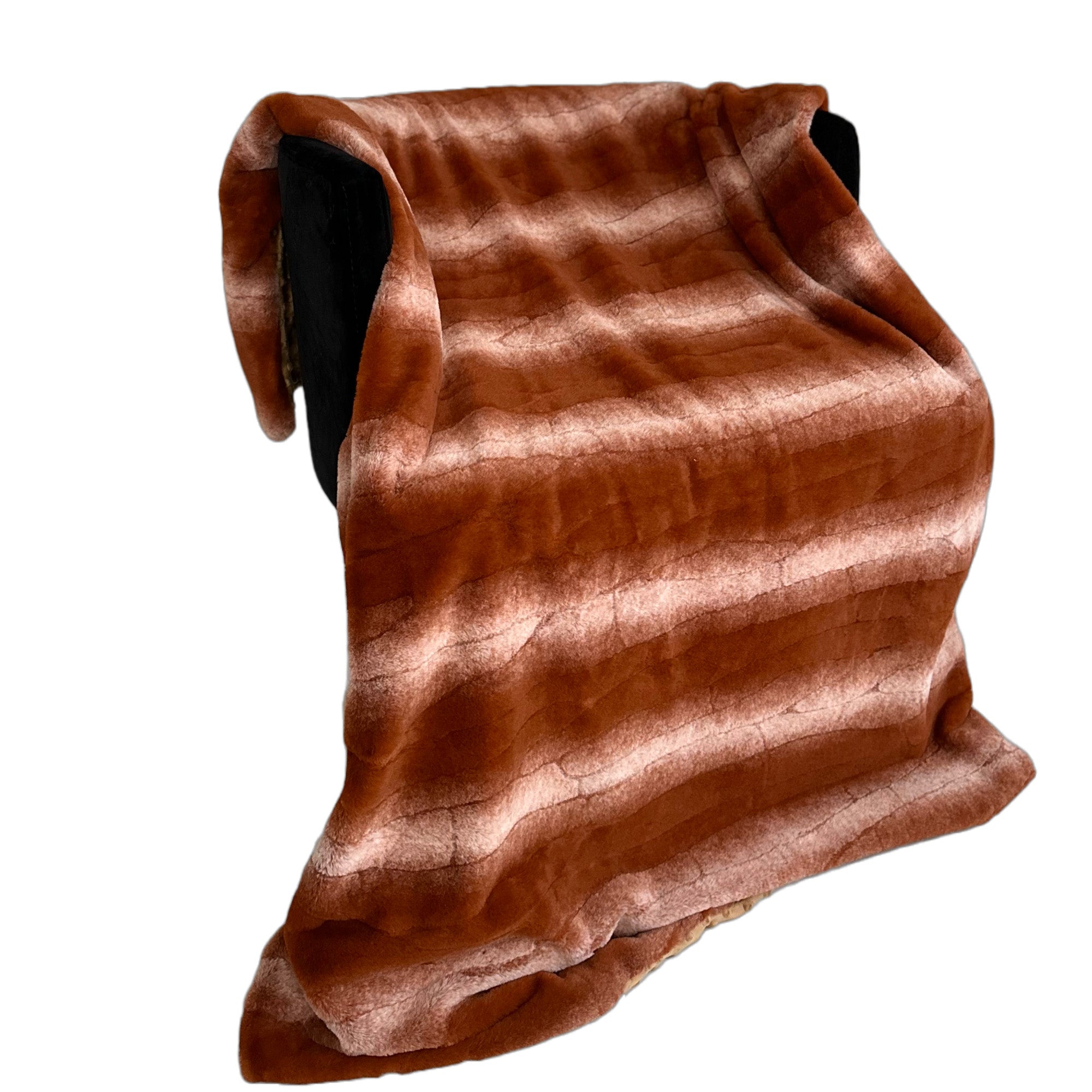 Plutus Orange Brown Faux Fur Luxury Throw Blanket draped elegantly over a couch, showcasing its rich color and soft texture.