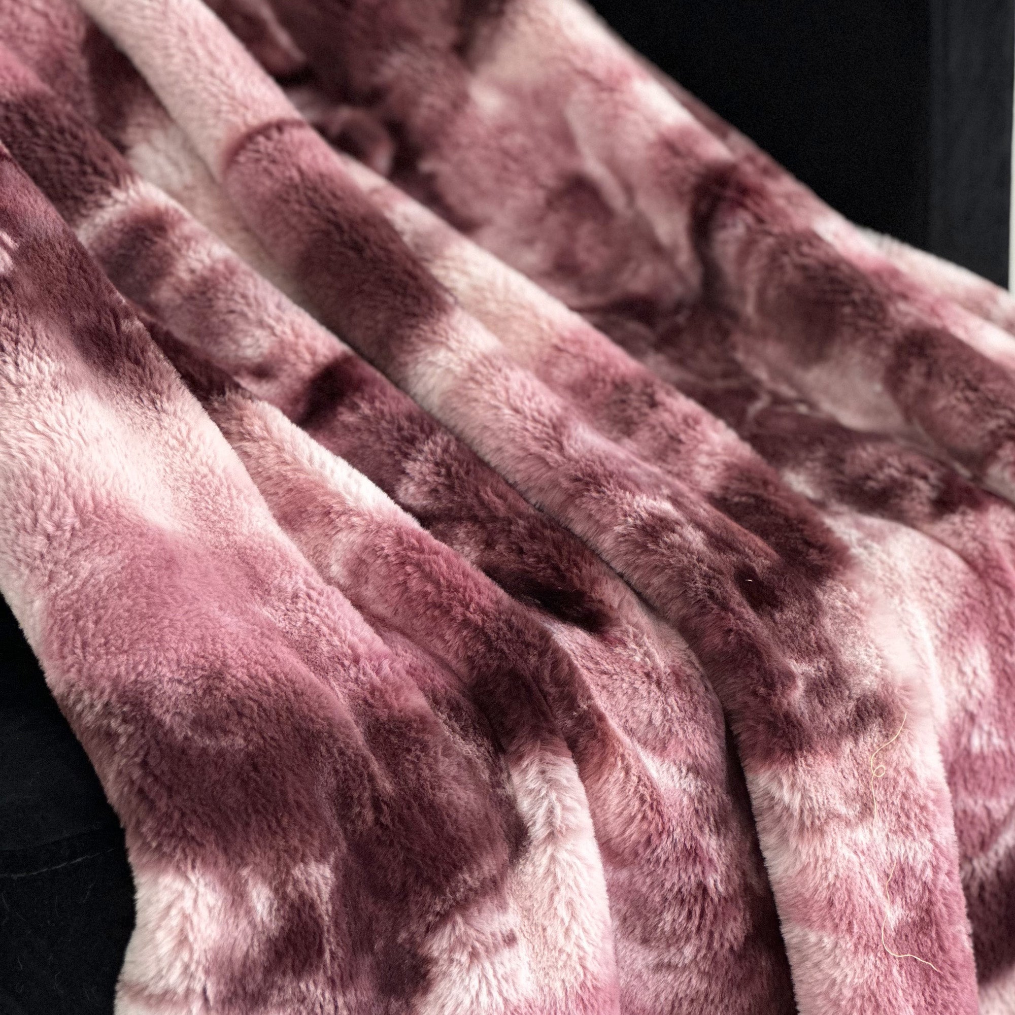 Plutus Rose Fureal Faux Fur Luxury Throw Blanket in elegant rose color, showcasing its soft texture and reversible design.