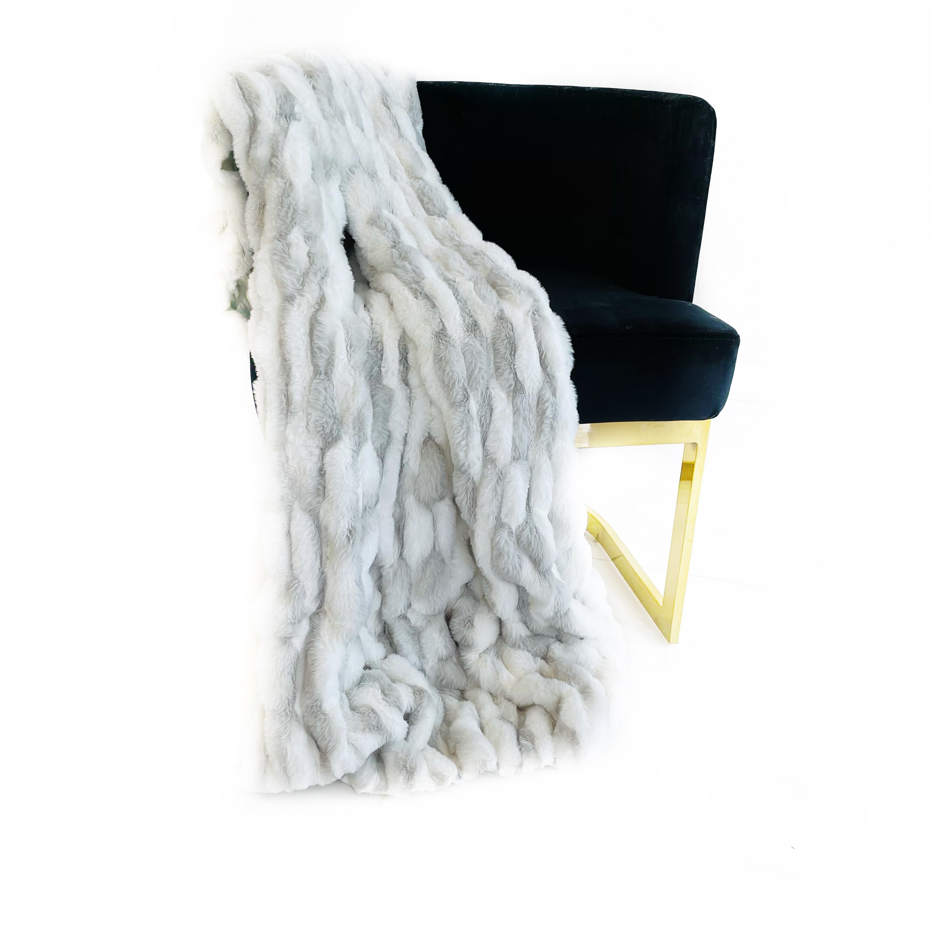 Plutus White Silver Snow Chinchilla Faux Fur Luxury Throw Blanket draped elegantly on a sofa, showcasing its plush texture and reversible design.