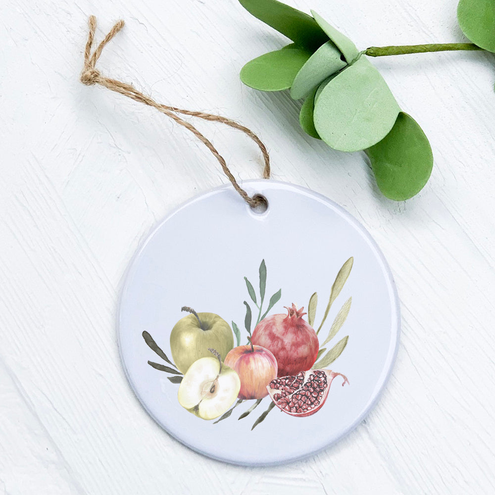 A beautifully crafted porcelain ornament featuring pomegranates and apples, showcasing vibrant colors and a glossy finish.