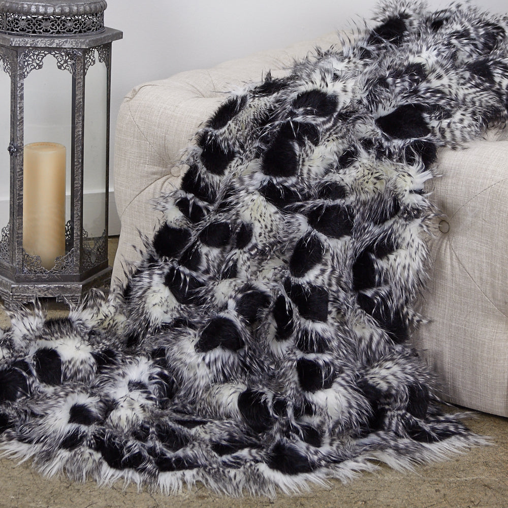 Porcupine Black and White Faux Fur Luxury Throw draped elegantly over a sofa, showcasing its plush texture and stylish design.