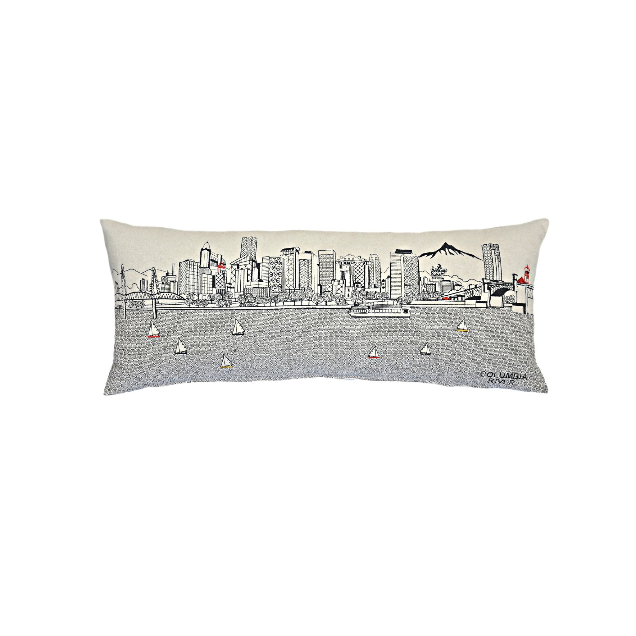 Portland Pillow featuring embroidered designs of iconic Portland landmarks and bridges, with a red zipper at the bottom.