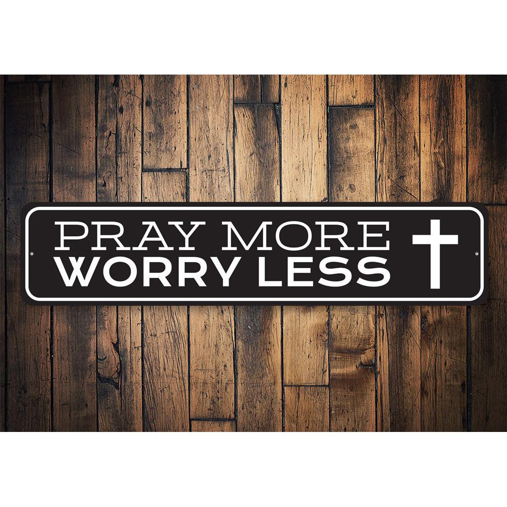 A decorative Pray More Worry Less sign made of durable aluminum, featuring a stylish design suitable for home decor.