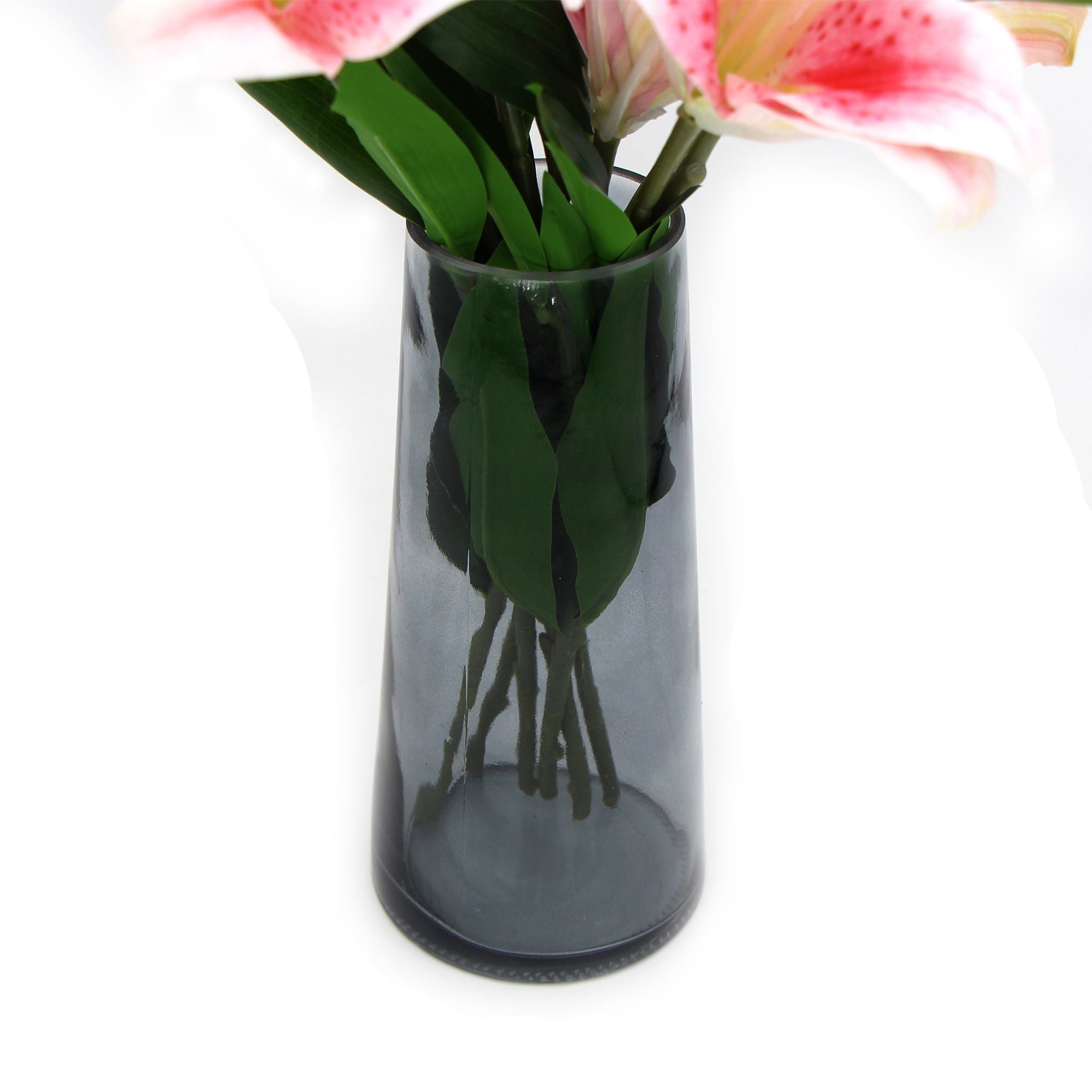 A beautiful arrangement of premium faux pink lilies in a clear glass vase, showcasing realistic flowers and foliage.