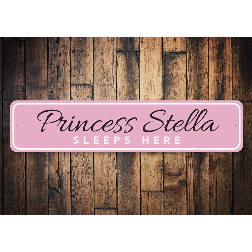 A decorative metal sign reading 'Princess Sleeps Here', featuring a charming design suitable for a child's room.