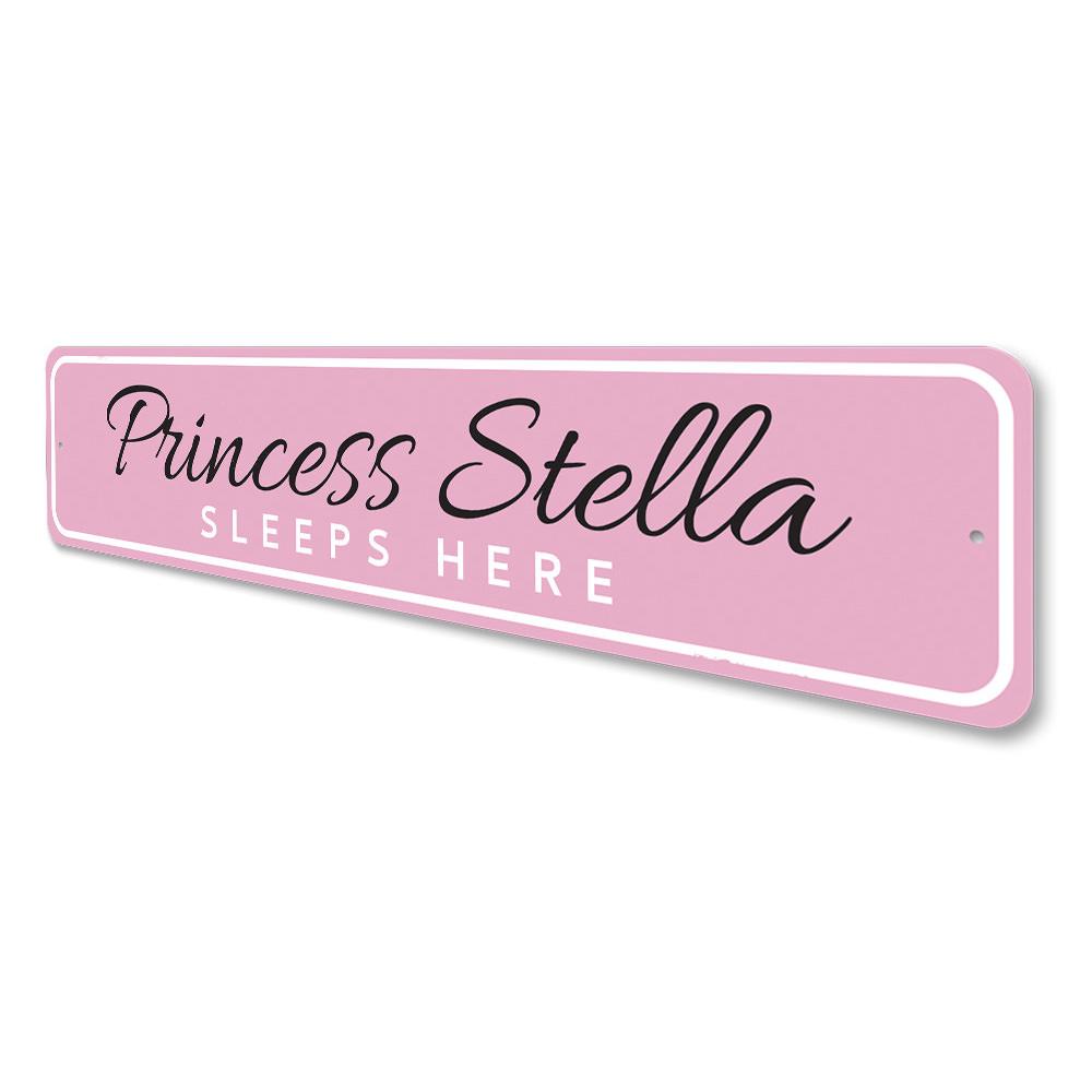 A decorative metal sign reading 'Princess Sleeps Here', featuring a charming design suitable for a child's room.