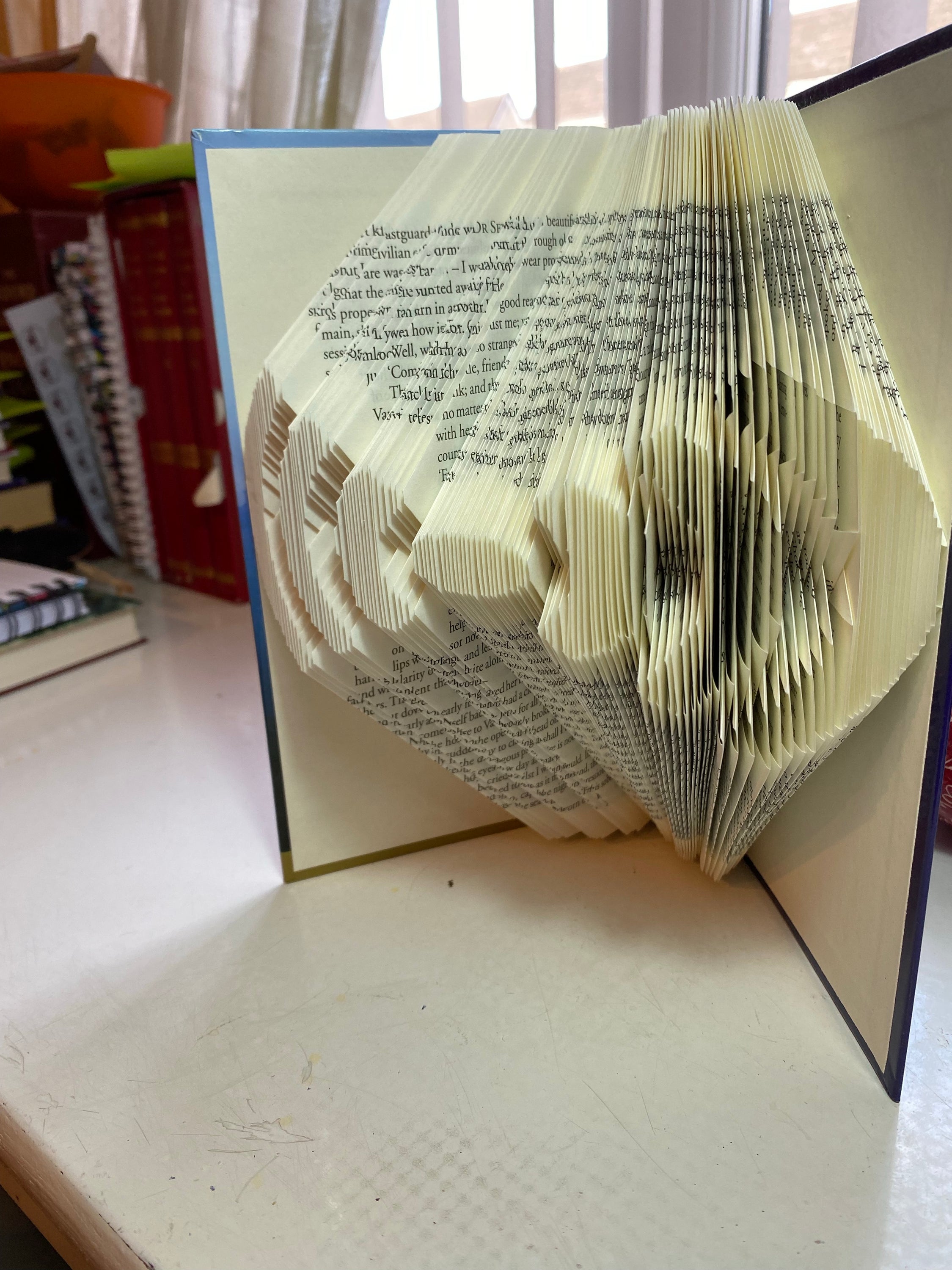 A handcrafted Radio Amplifier made from vintage books, showcasing unique hand-folded pages in an artistic design.