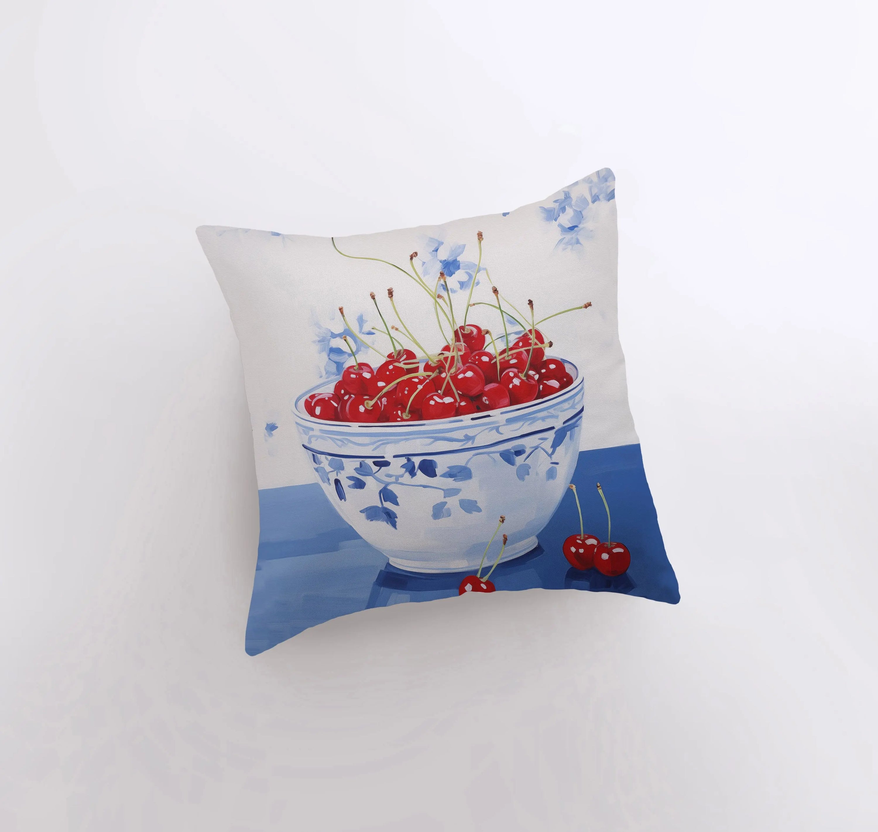 A vibrant Red Cherry Bowl pillow featuring a gouache painting design, showcasing cherries in a bowl against a white background.