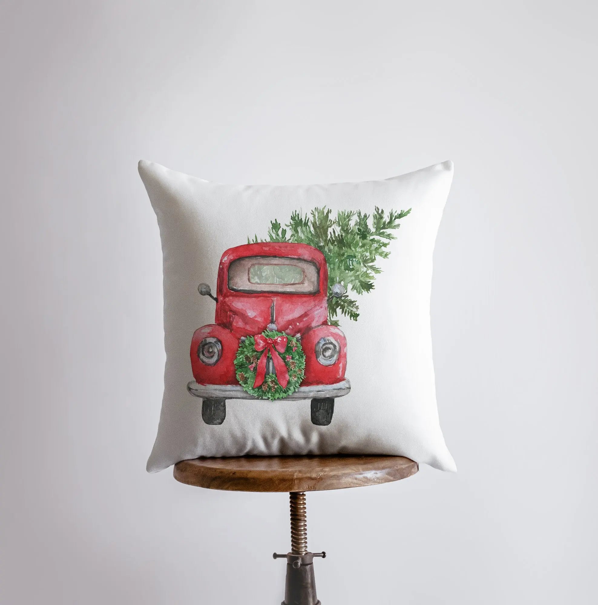 Red Christmas Truck Pillow Cover featuring a vintage truck hauling a Christmas tree and wreath, set against a white background.