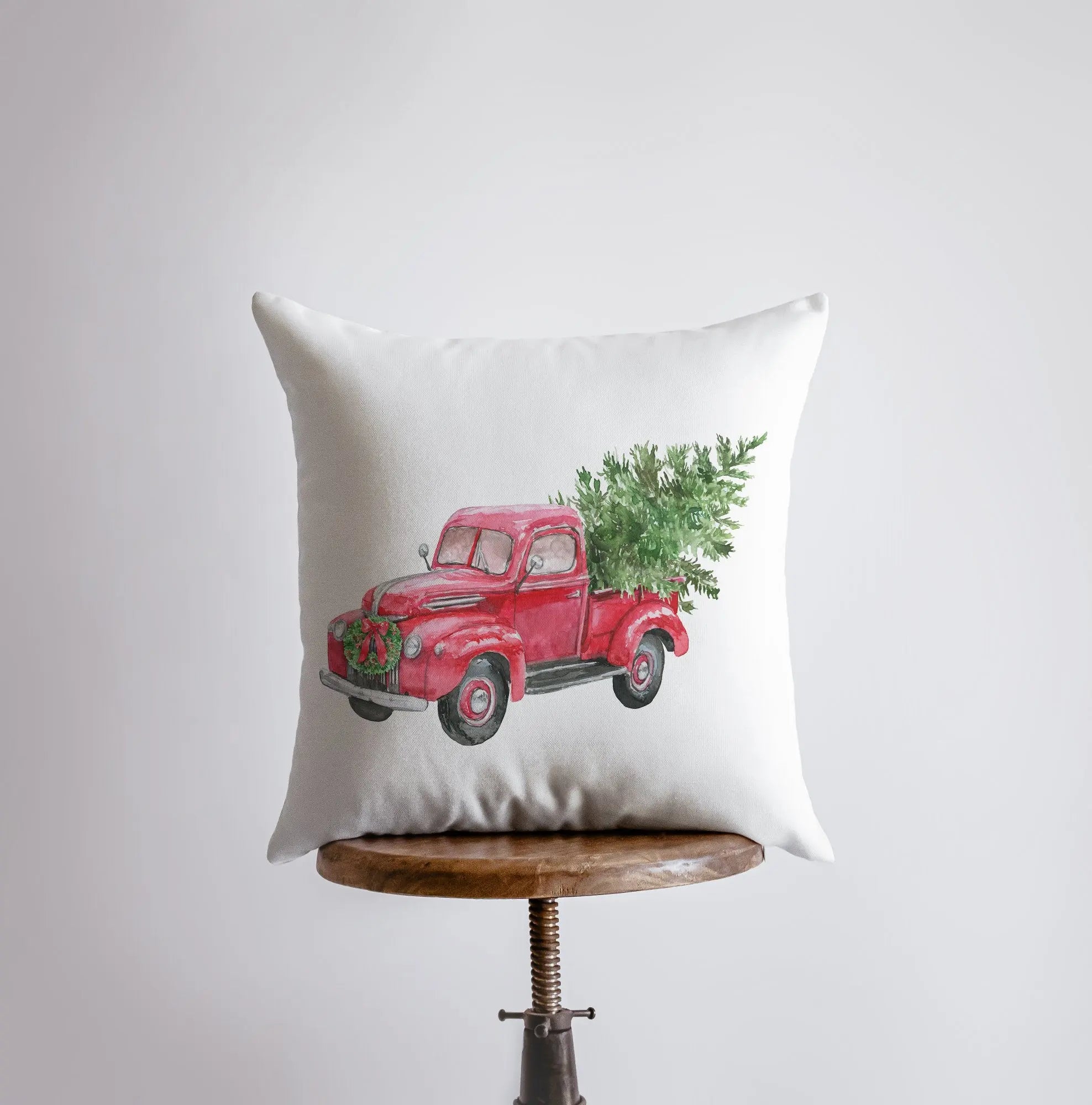 Red Christmas truck hauling a Christmas tree, featured on a decorative pillow cover with a solid white back.