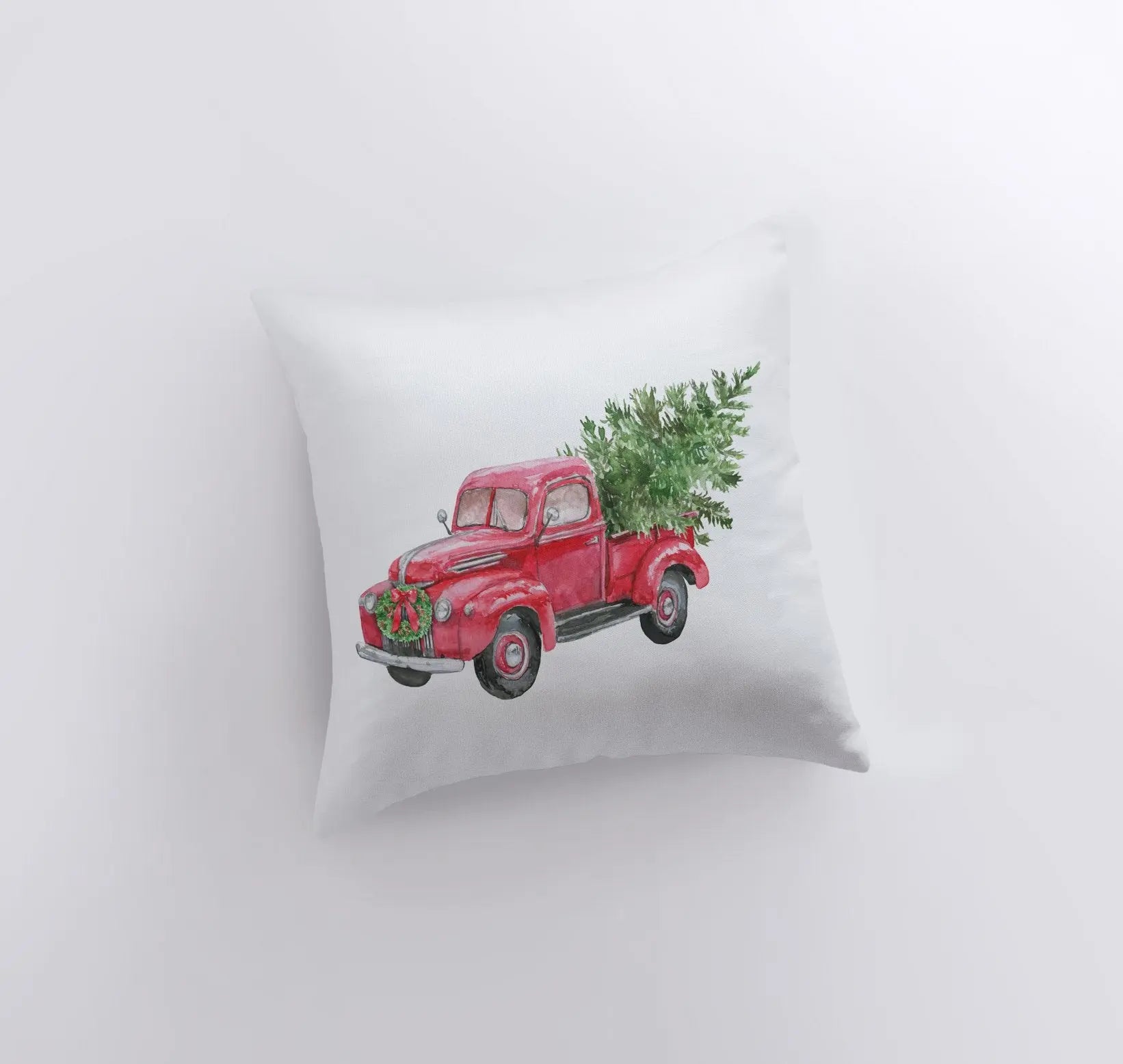 Red Christmas truck hauling a Christmas tree, featured on a decorative pillow cover with a solid white back.