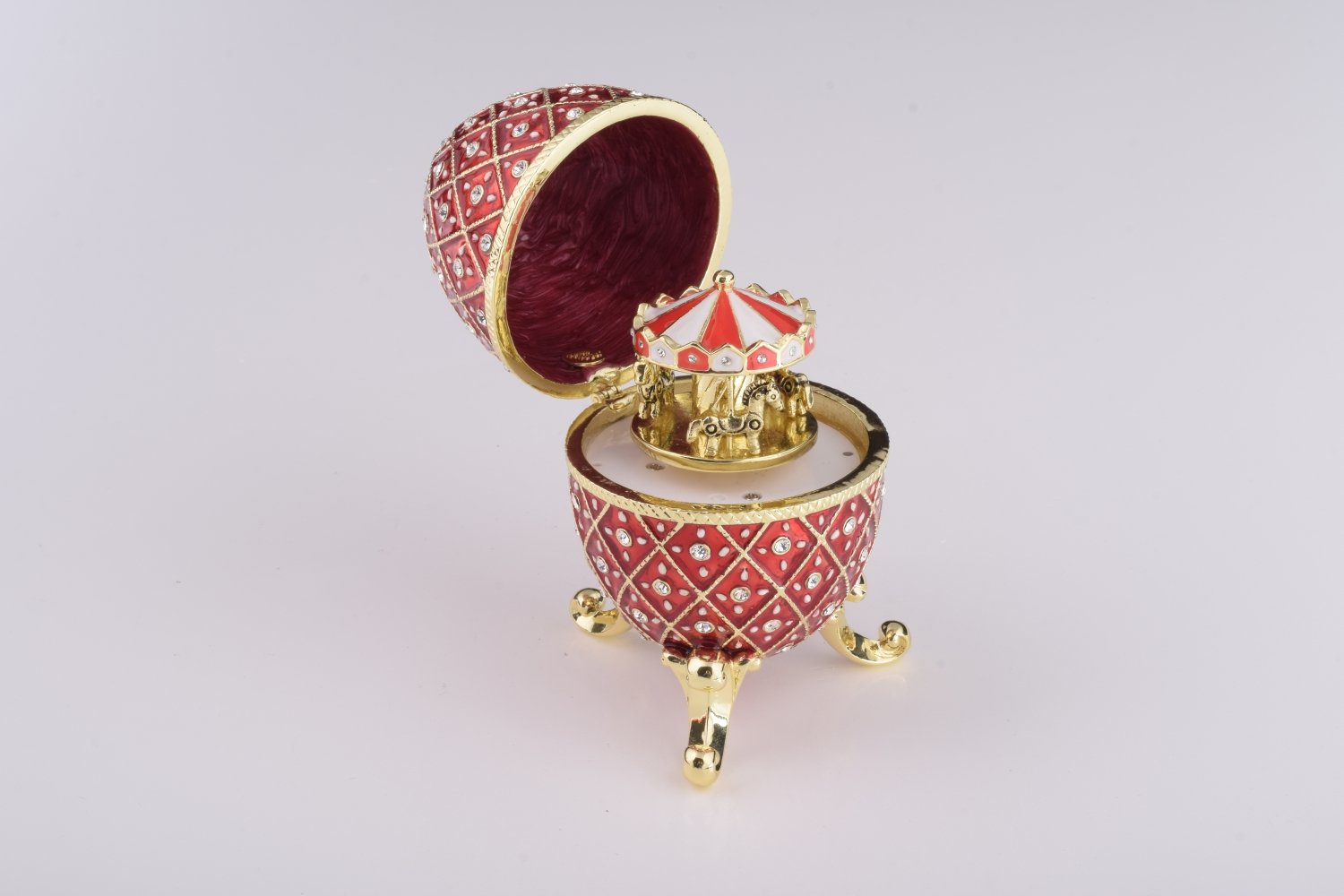 A stunning Red Faberge Egg trinket box featuring a horse carousel surprise inside, adorned with Austrian crystals and 24K gold plating.