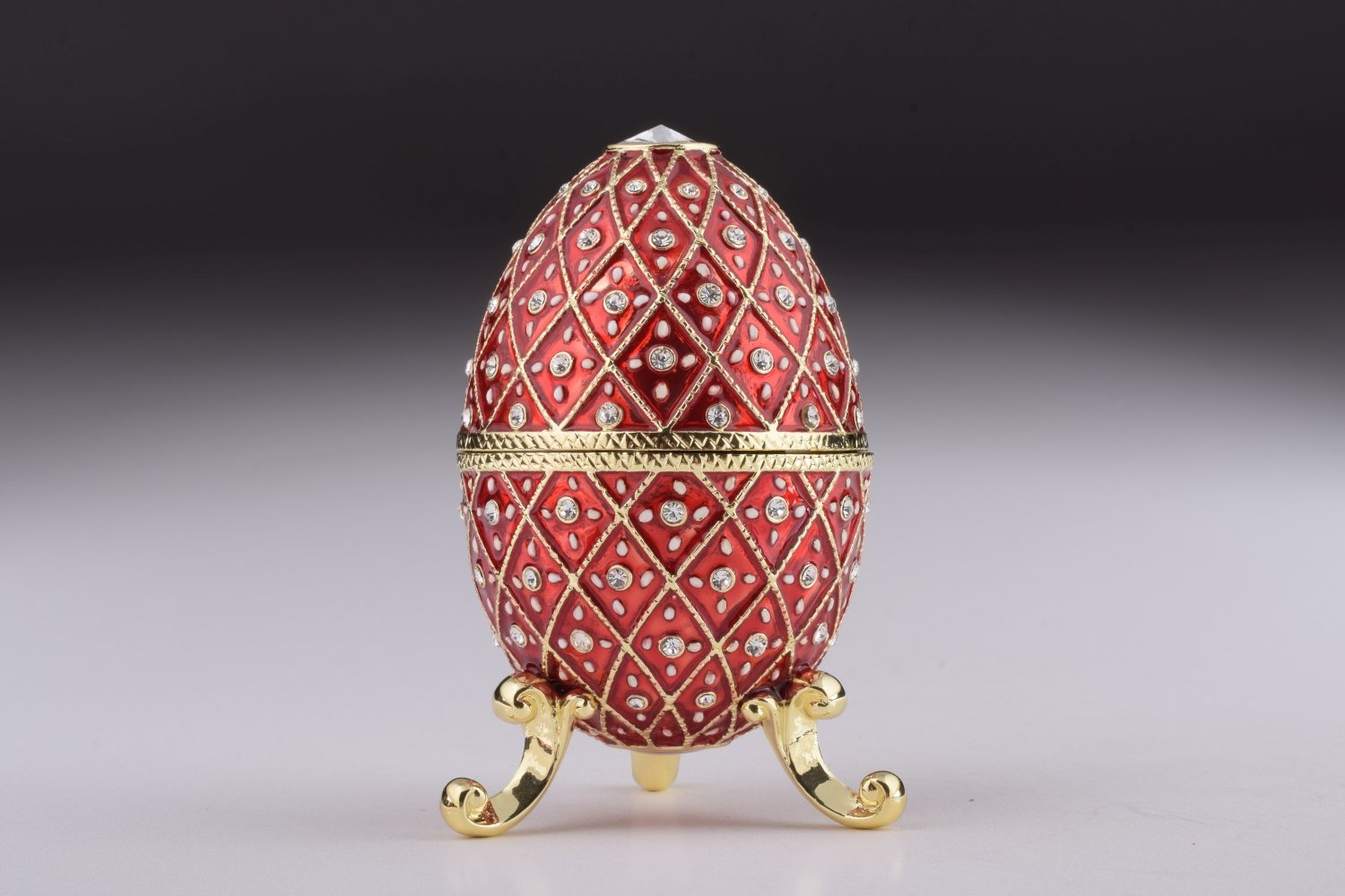 A stunning Red Faberge Egg trinket box featuring a horse carousel surprise inside, adorned with Austrian crystals and 24K gold plating.