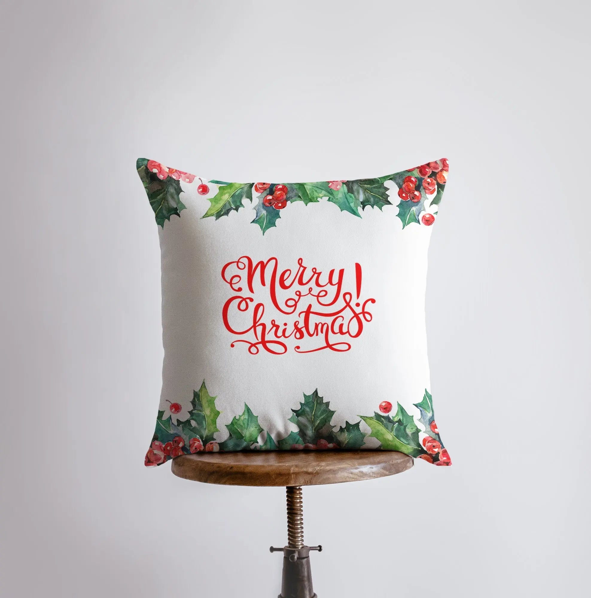 Red Merry Christmas Holly pillow cover featuring elegant cursive text and holly berry design on a white background.