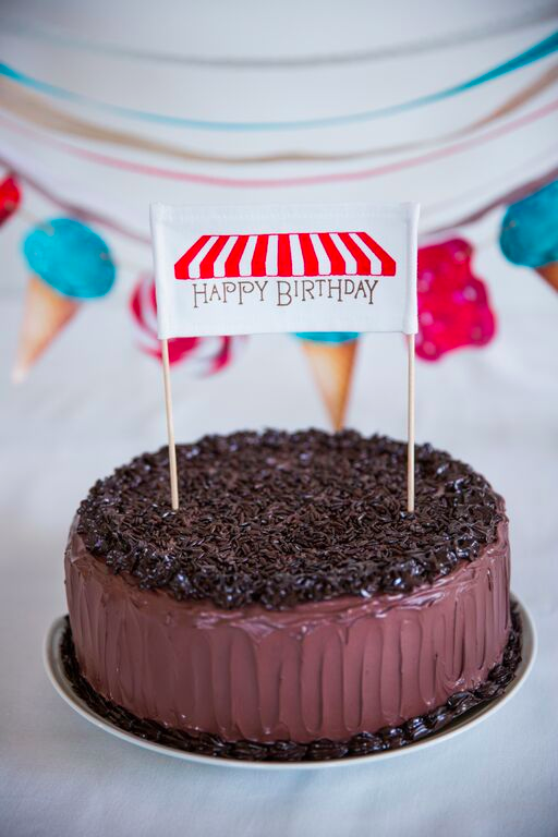 A vibrant red fabric cake banner, 5 inches wide and 9 inches tall, with mounting sticks for easy decoration.