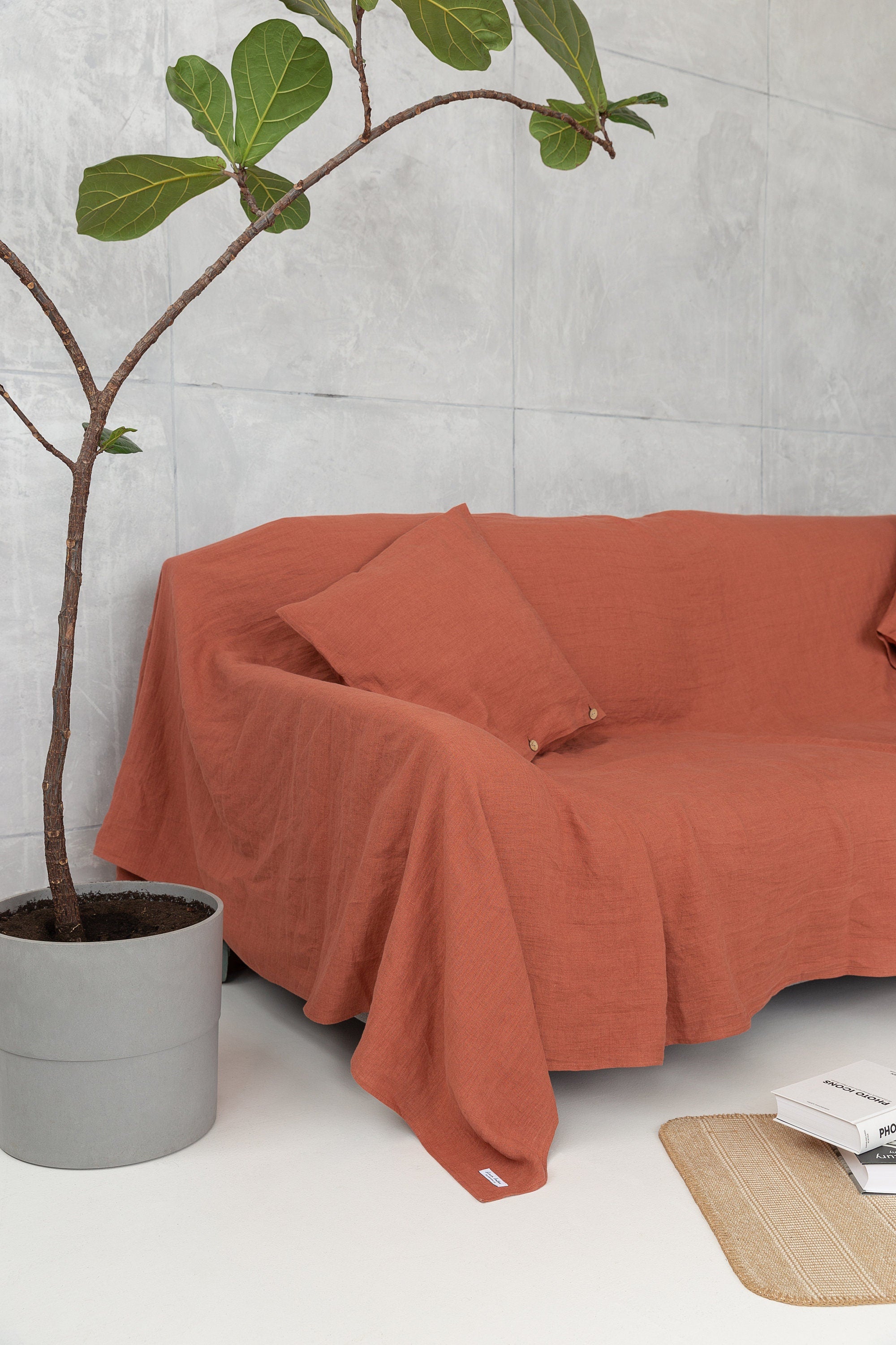 Reddish brown linen couch cover draped elegantly over a sofa, showcasing its soft texture and rich color.