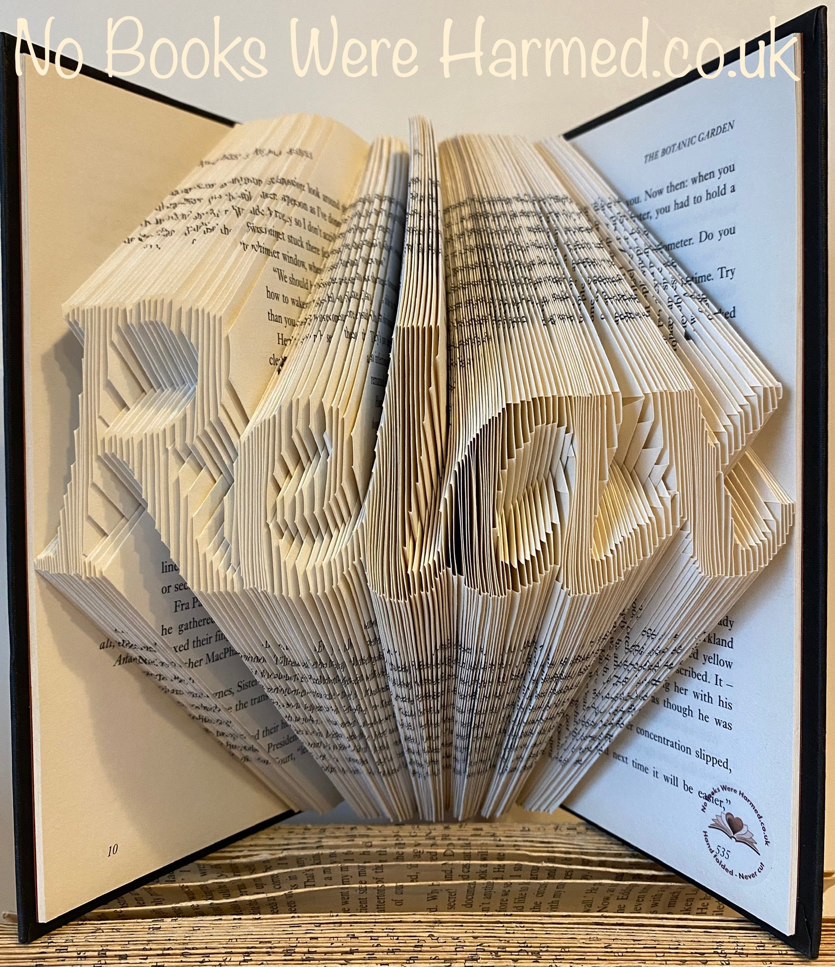 Hand-folded book art piece from the Relax collection, showcasing intricate designs made from vintage book pages.