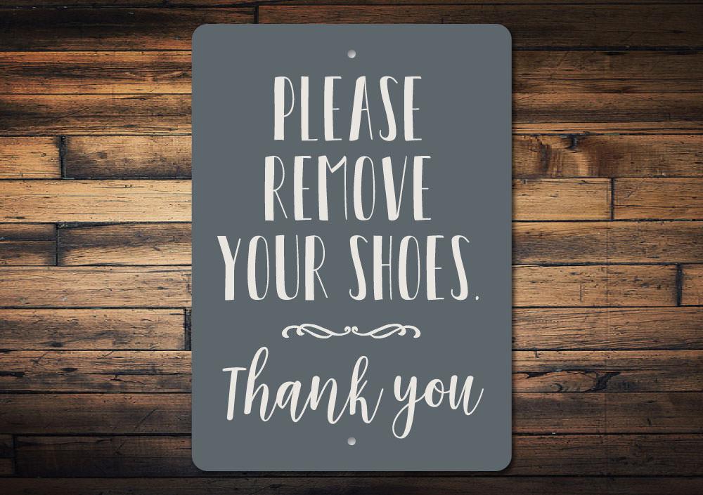 A decorative Remove Shoes Sign made of durable aluminum, featuring customizable text options, ideal for entryways.