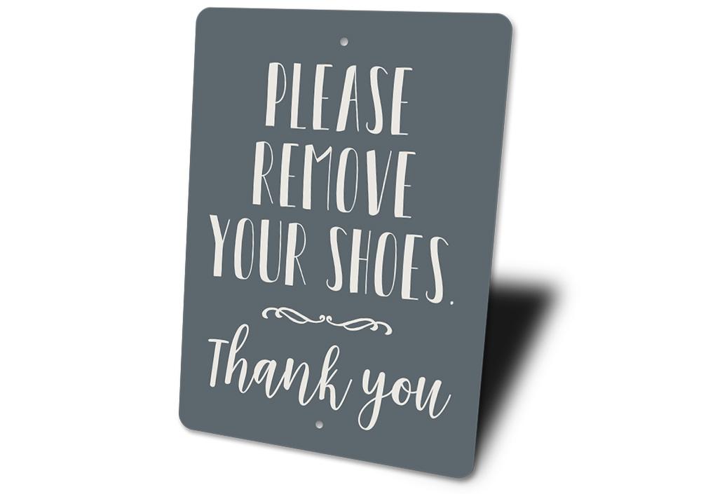 A decorative Remove Shoes Sign made of durable aluminum, featuring customizable text options, ideal for entryways.