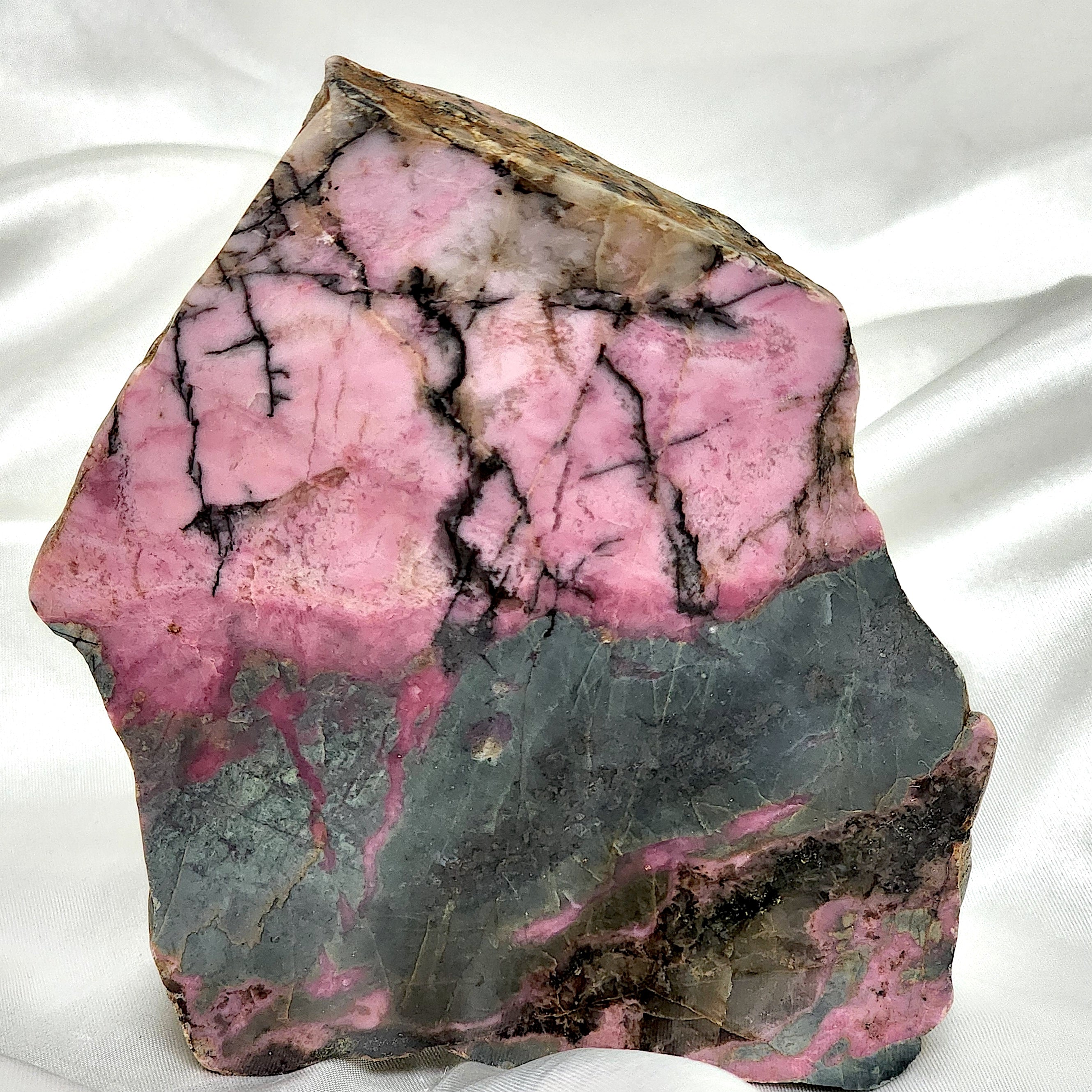 A collection of unique Rhodonite Freeform Slabs showcasing their pink and black patterns, perfect for emotional healing and decoration.