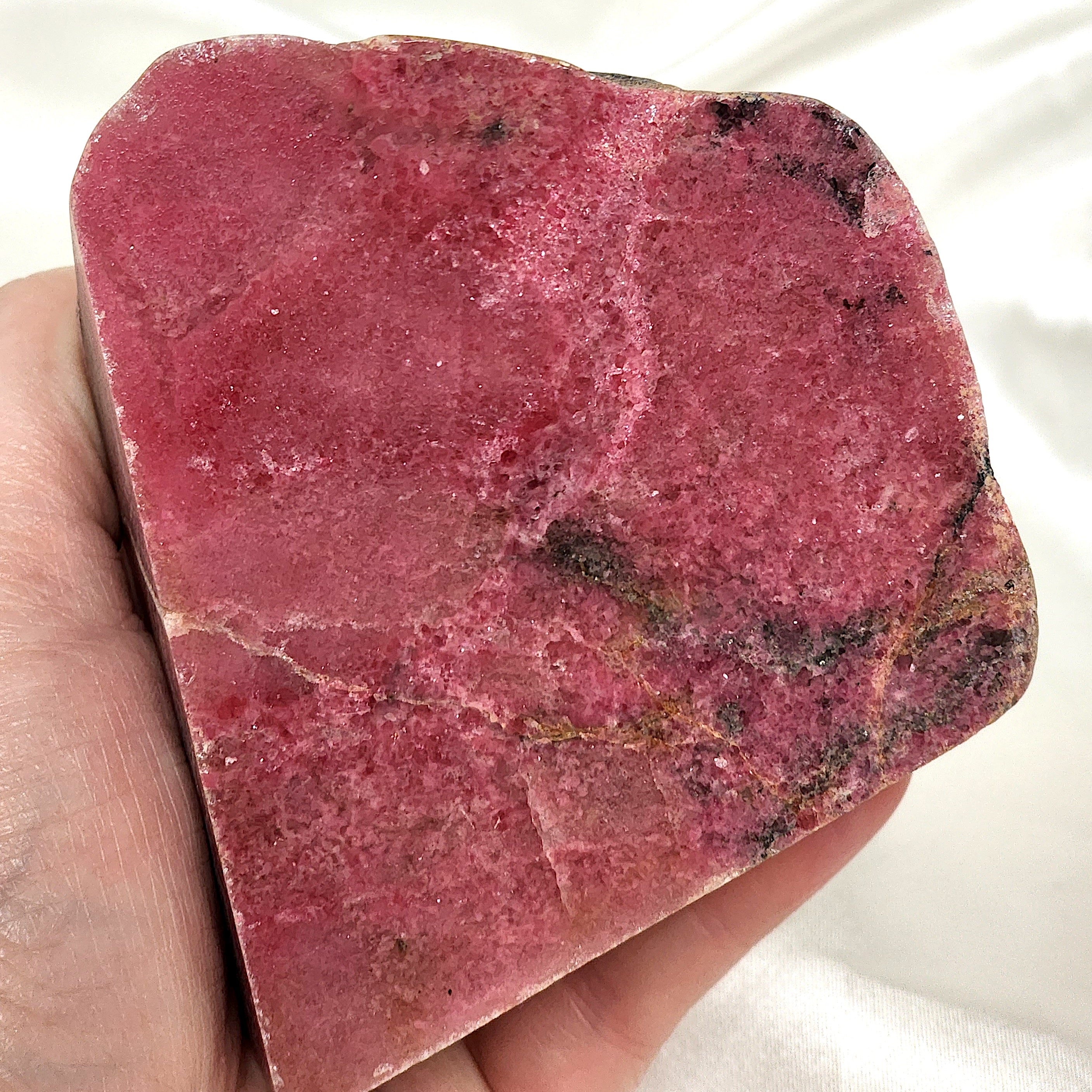 A collection of unique Rhodonite Freeform Slabs showcasing their pink and black patterns, perfect for emotional healing and decoration.