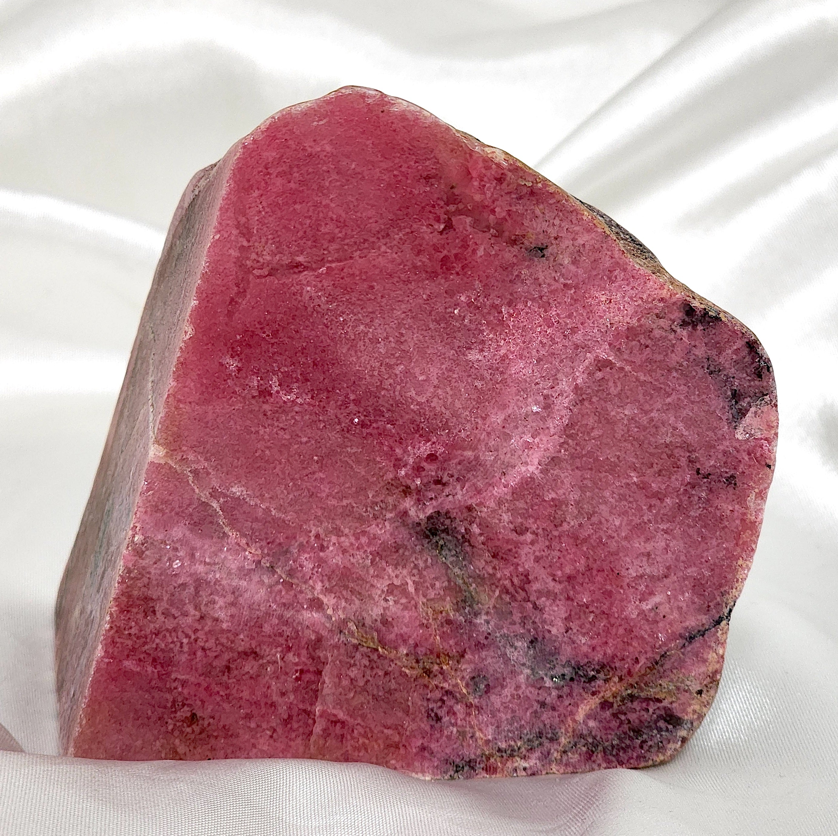 A collection of unique Rhodonite Freeform Slabs showcasing their pink and black patterns, perfect for emotional healing and decoration.