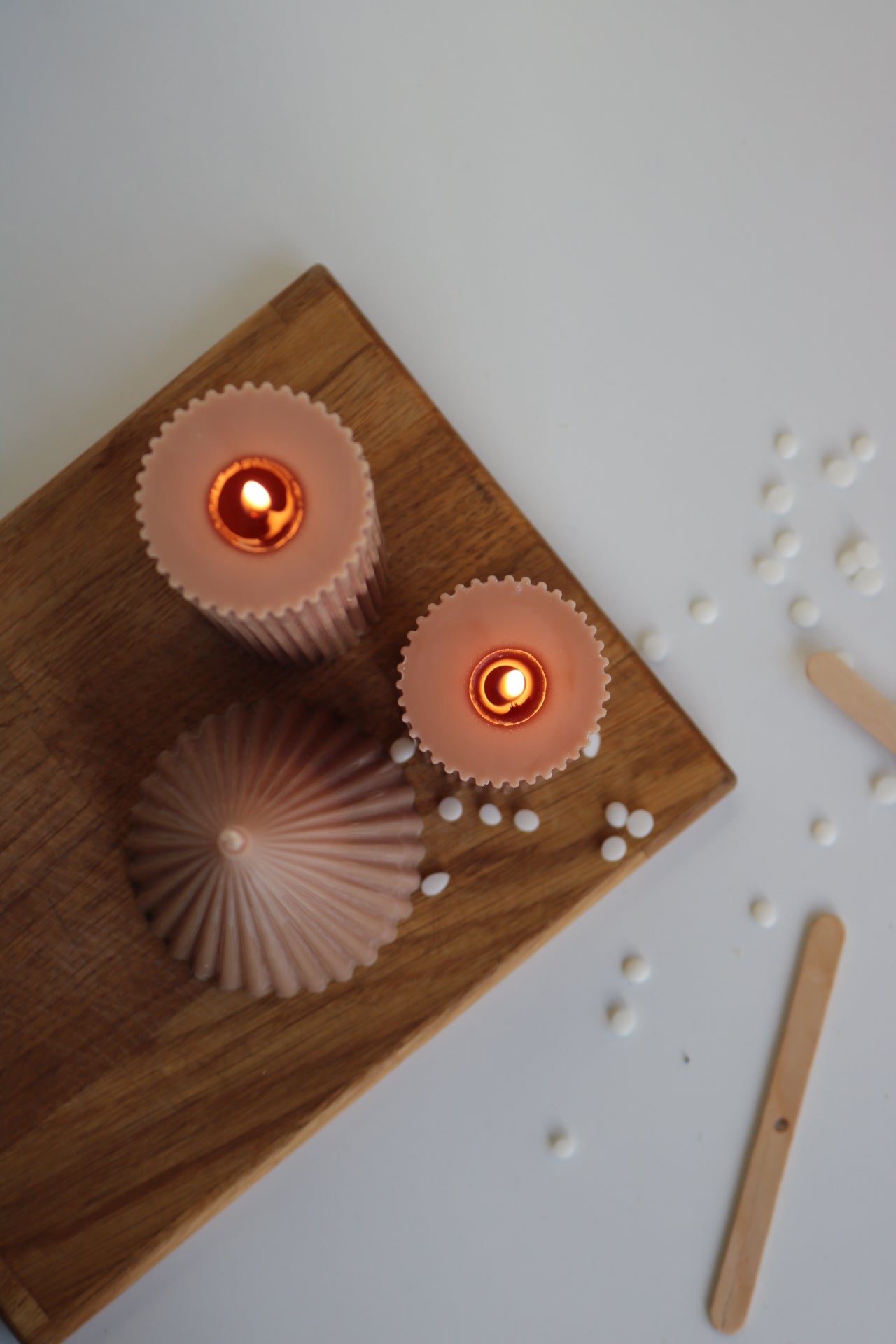 A decorative set of three ribbed pillar candles in varying heights, showcasing an elegant design made from a soy wax blend.