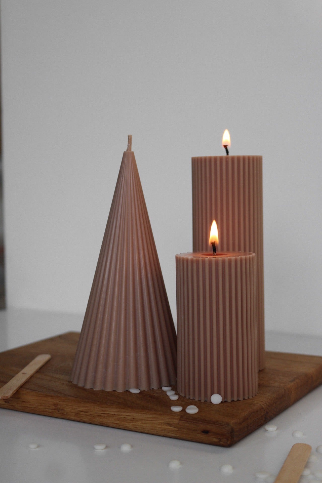 A decorative set of three ribbed pillar candles in varying heights, showcasing an elegant design made from a soy wax blend.