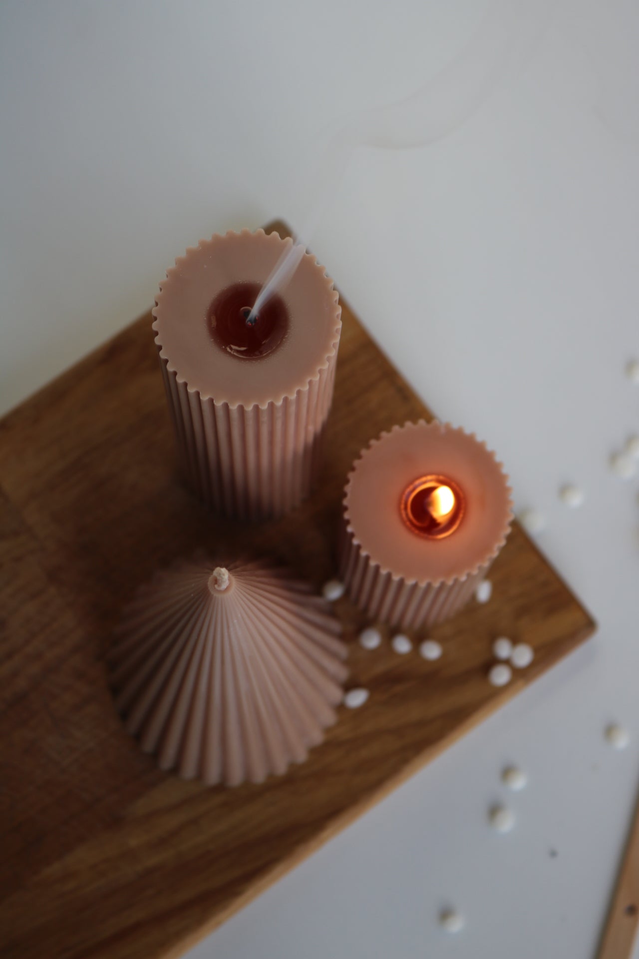 A decorative set of three ribbed pillar candles in varying heights, showcasing an elegant design made from a soy wax blend.