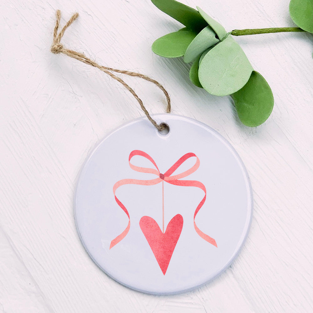 A beautifully crafted Ribbon Heart Ornament made of high-quality porcelain, featuring a vibrant design, perfect for gifting or home decoration.