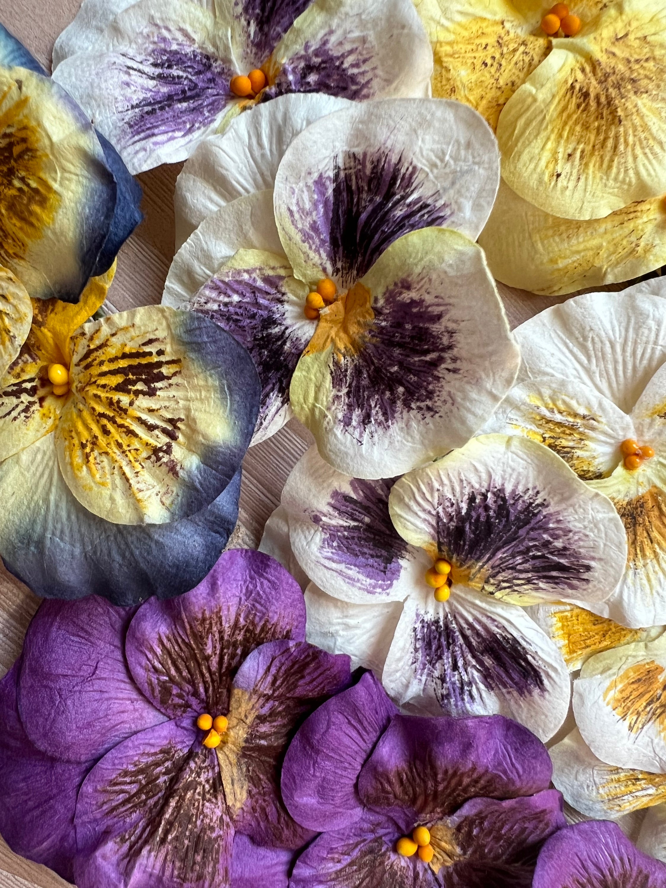 A bundle of 6 handcrafted rice paper pansy flowers in assorted colors with green floral wire stems, perfect for floral arrangements.