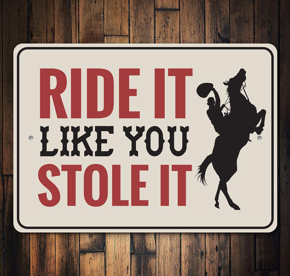 A decorative 'Ride It Like You Stole It' sign made of high-quality aluminum, featuring vibrant colors and a rustic design, perfect for barn or farmhouse decor.