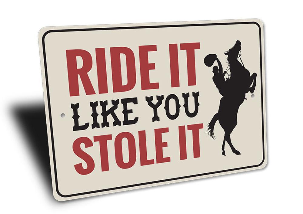 A decorative 'Ride It Like You Stole It' sign made of high-quality aluminum, featuring vibrant colors and a rustic design, perfect for barn or farmhouse decor.