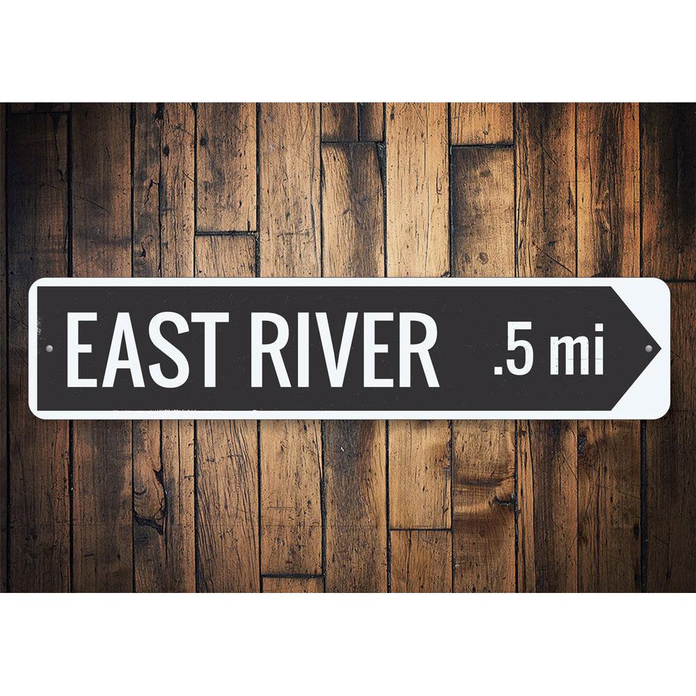 A decorative River Arrow Sign made of high-quality aluminum, featuring customizable text and pre-drilled holes for easy mounting.