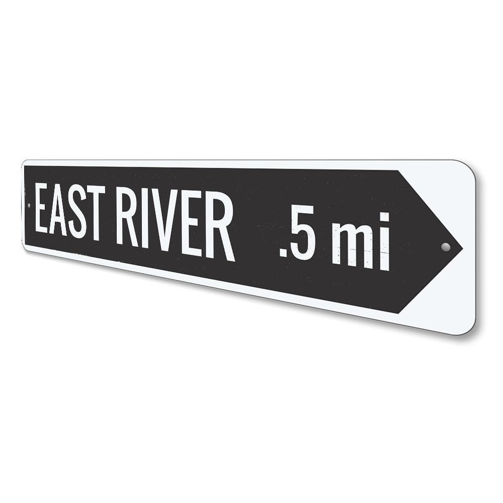 A decorative River Arrow Sign made of high-quality aluminum, featuring customizable text and pre-drilled holes for easy mounting.