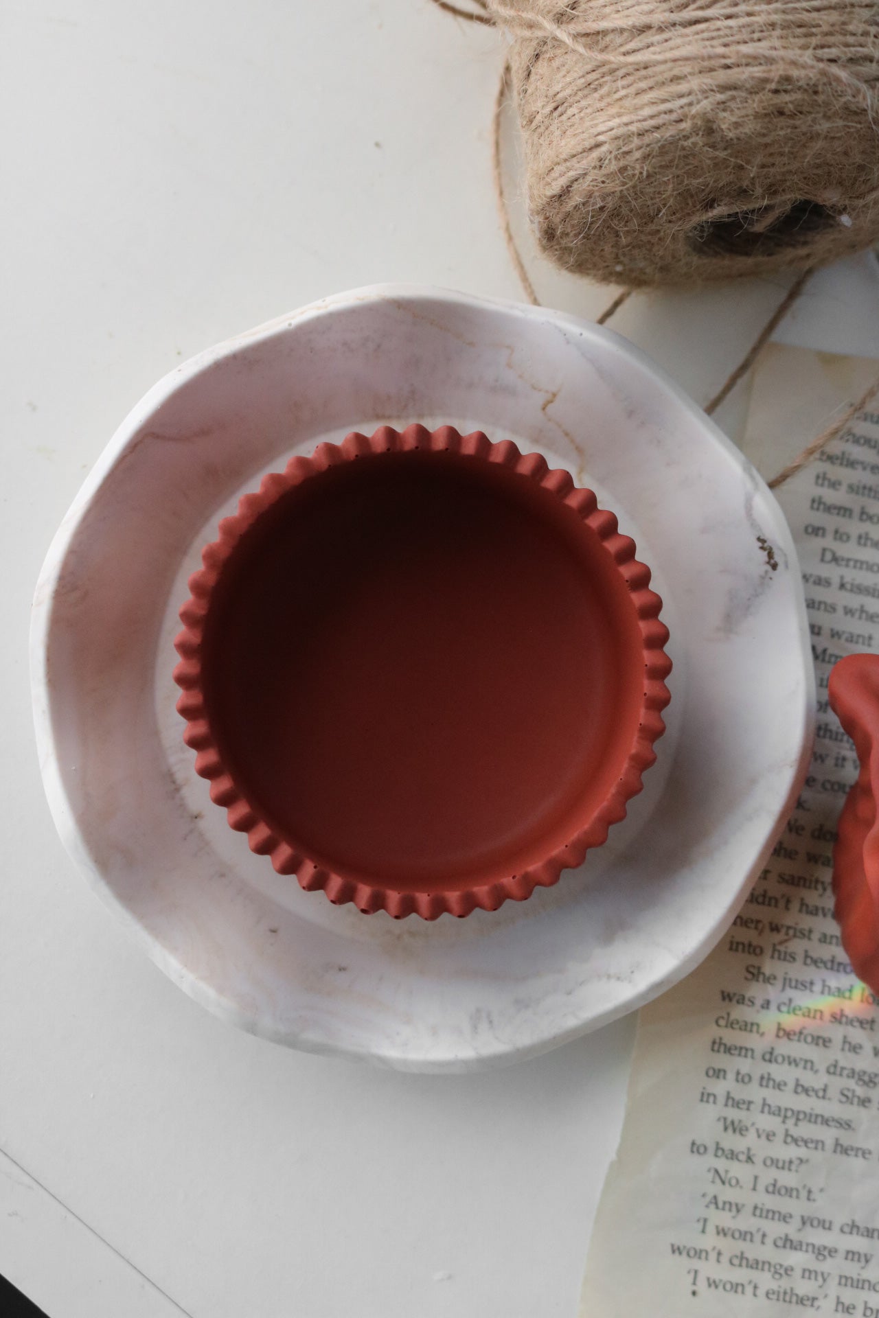 A round asymmetrical scallop tray in various colors, showcasing its unique handmade design and elegant scalloped edges.