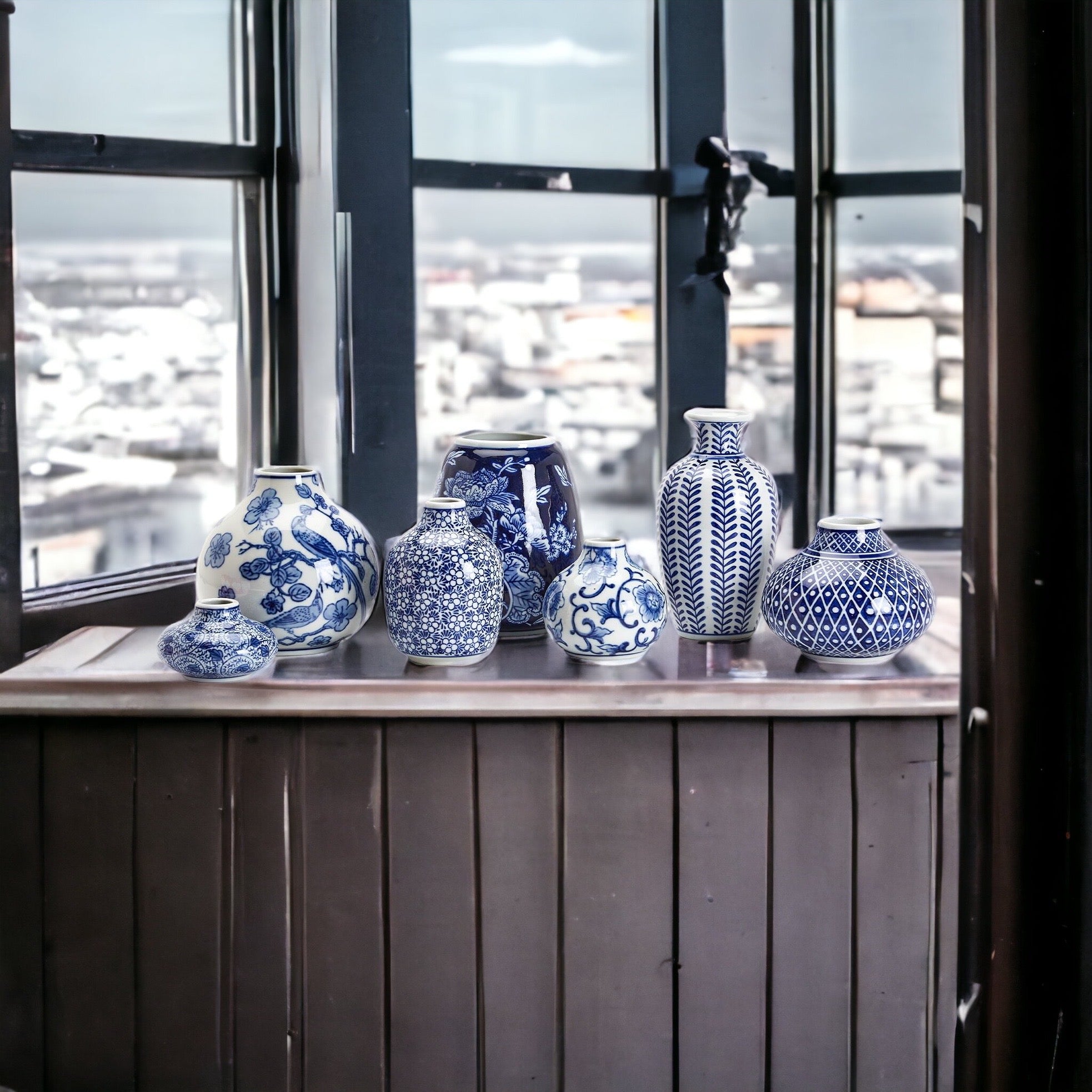 A collection of Samira Blue Vases featuring hand-painted porcelain in classic blue and white designs, showcasing various sizes and styles.