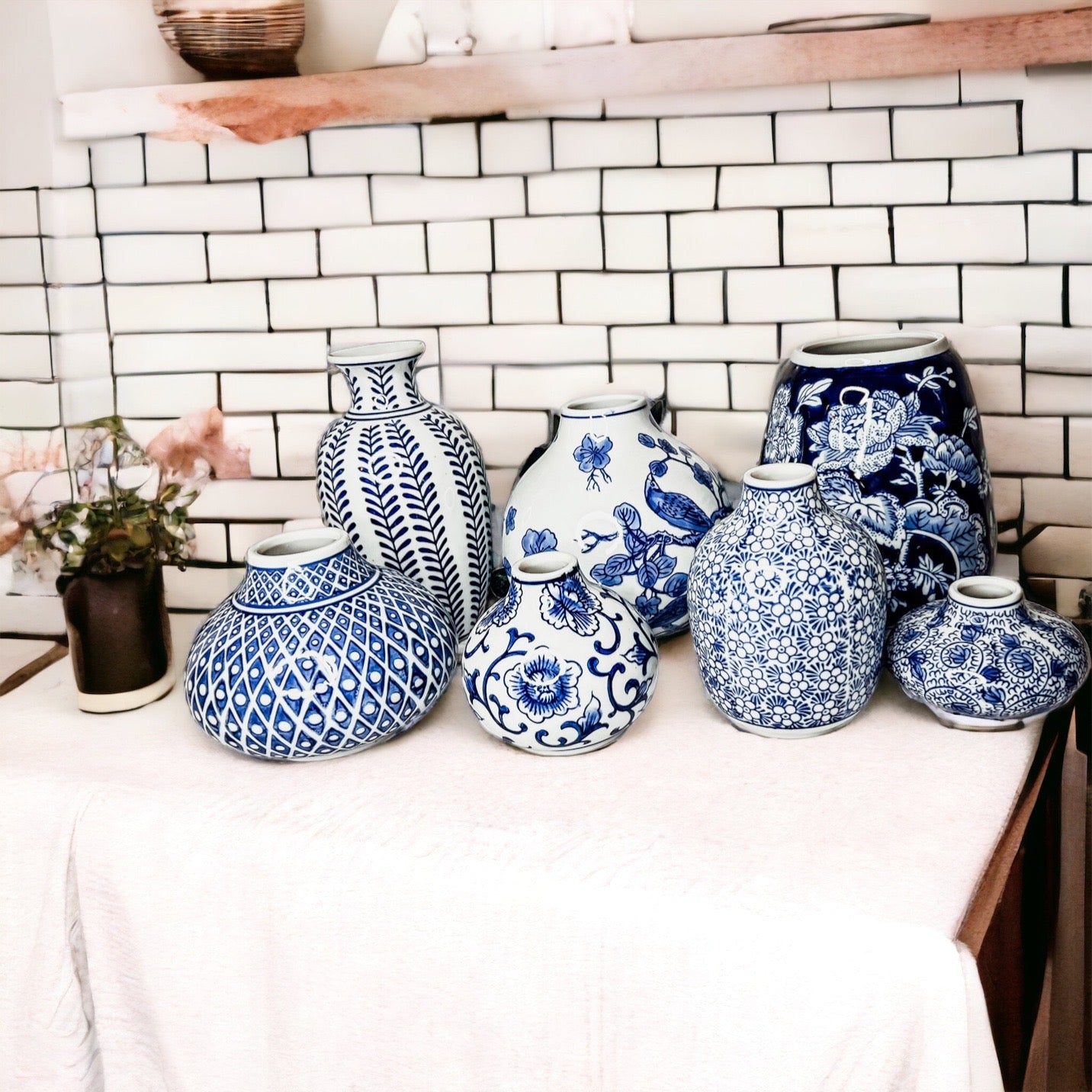 A collection of Samira Blue Vases featuring hand-painted porcelain in classic blue and white designs, showcasing various sizes and styles.