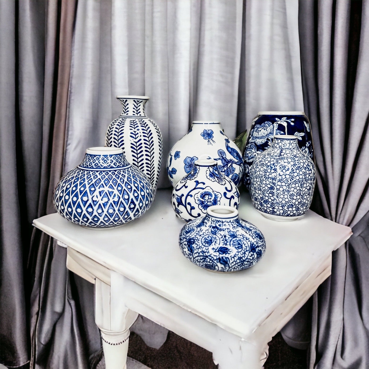 A collection of Samira Blue Vases featuring hand-painted porcelain in classic blue and white designs, showcasing various sizes and styles.