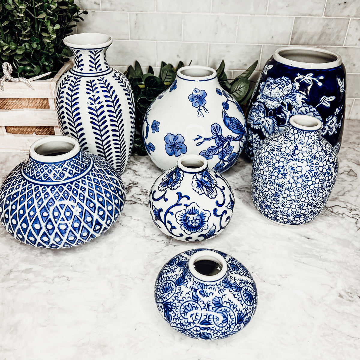 A collection of Samira Blue Vases featuring hand-painted porcelain in classic blue and white designs, showcasing various sizes and styles.