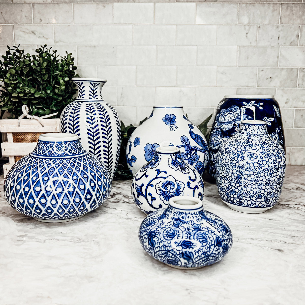 A collection of Samira Blue Vases featuring hand-painted porcelain in classic blue and white designs, showcasing various sizes and styles.