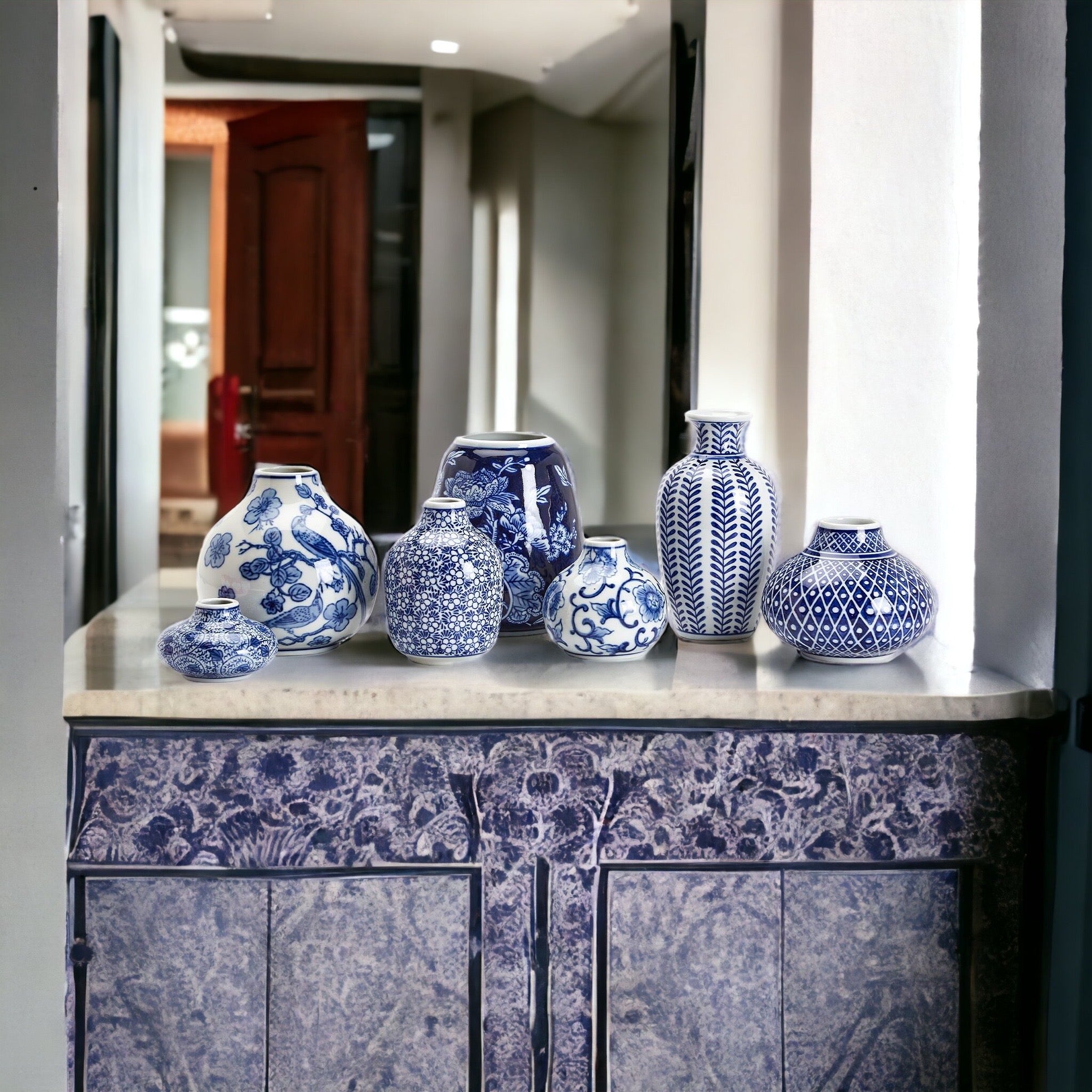 A collection of Samira Blue Vases featuring hand-painted porcelain in classic blue and white designs, showcasing various sizes and styles.