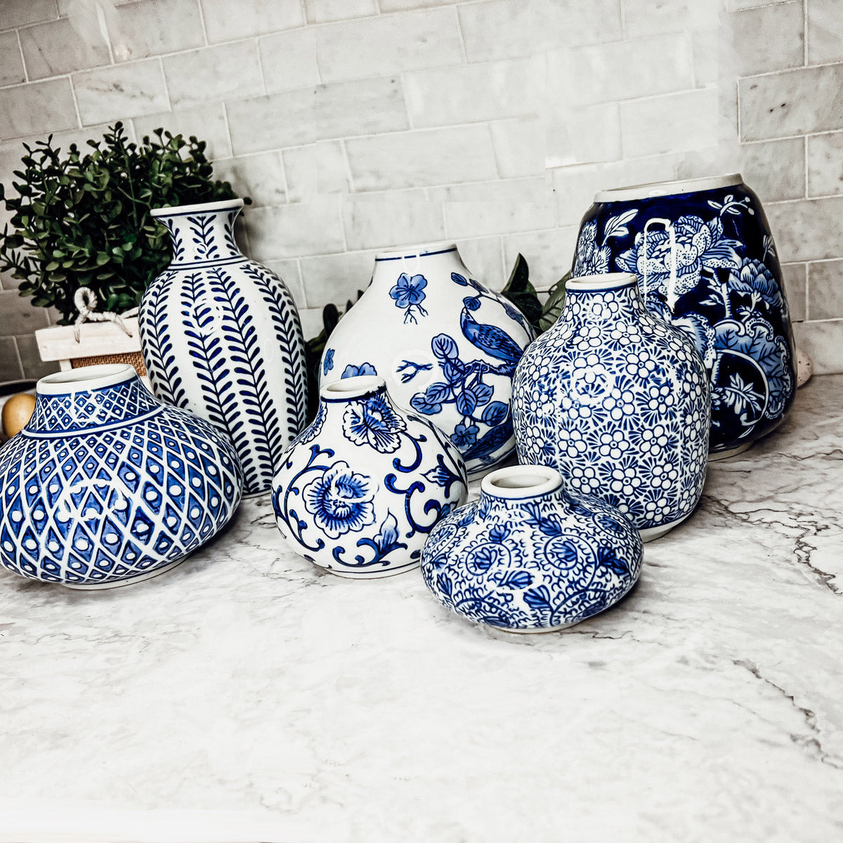 A collection of Samira Blue Vases featuring hand-painted porcelain in classic blue and white designs, showcasing various sizes and styles.