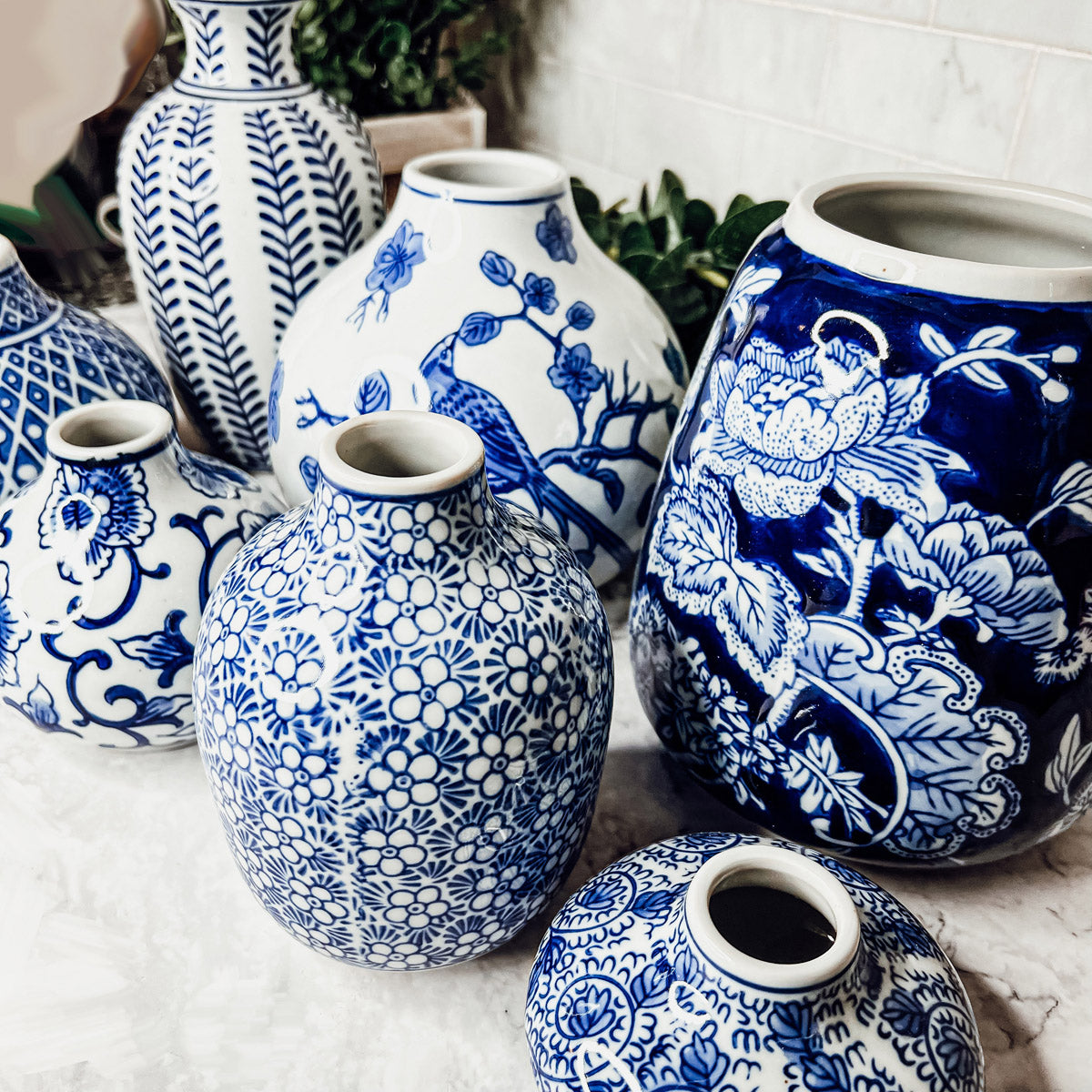 A collection of Samira Blue Vases featuring hand-painted porcelain in classic blue and white designs, showcasing various sizes and styles.