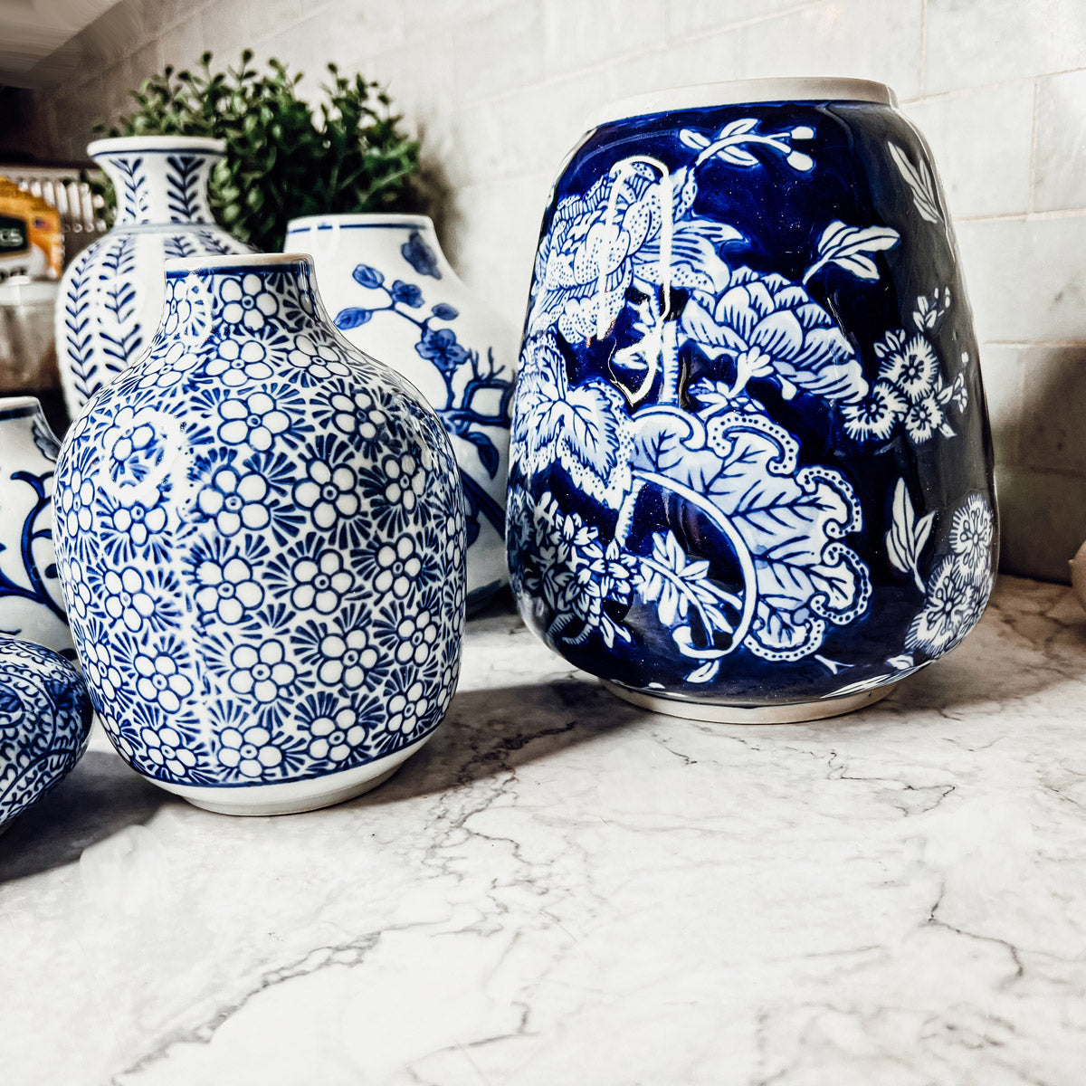 A collection of Samira Blue Vases featuring hand-painted porcelain in classic blue and white designs, showcasing various sizes and styles.