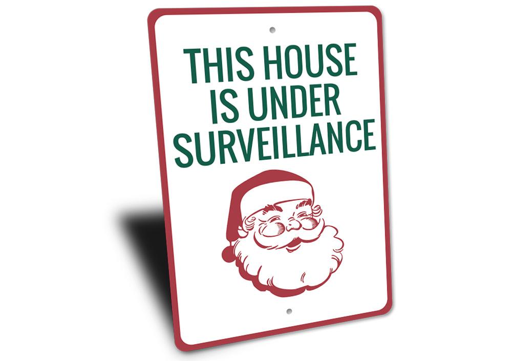 A festive Santa Surveillance Sign made of durable aluminum, featuring a whimsical design perfect for holiday decorations.