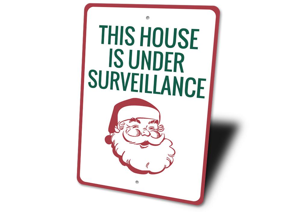 A festive Santa Surveillance Sign made of durable aluminum, featuring a whimsical design perfect for holiday decorations.