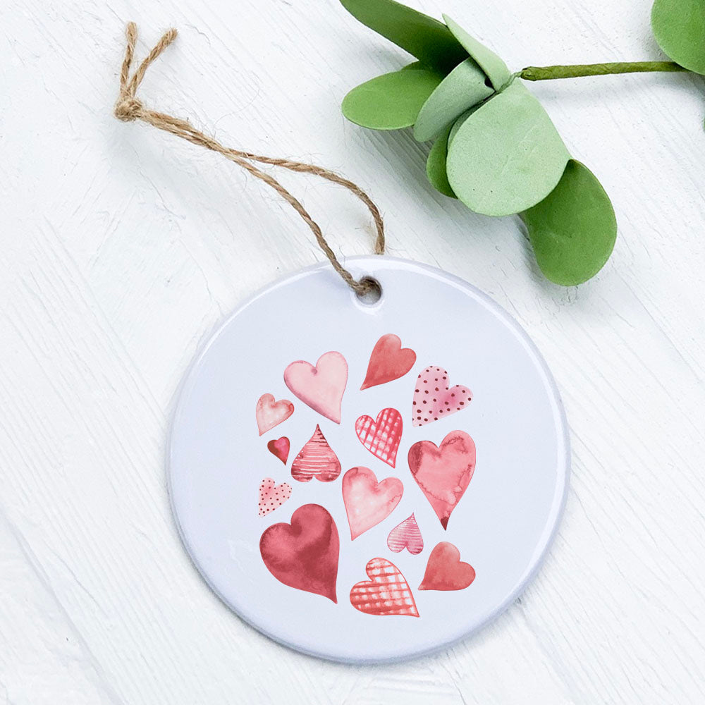 Scattered Hearts Ornament made of high-quality porcelain with a glossy finish, featuring a vibrant heart design.