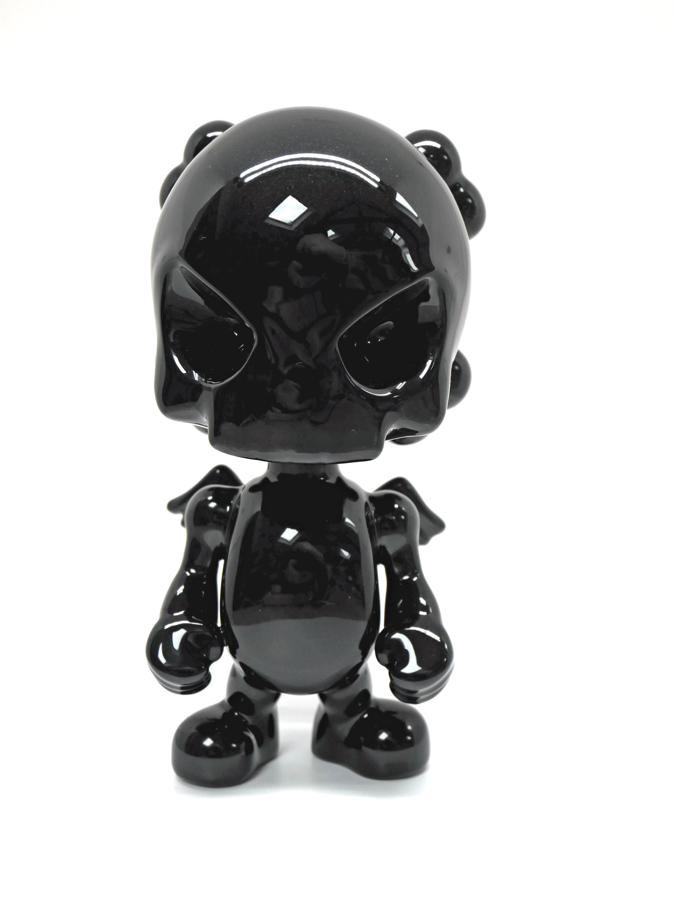 SkullHead Black Porcelain sculpture by Huck Gee, showcasing intricate details and a sleek black finish.